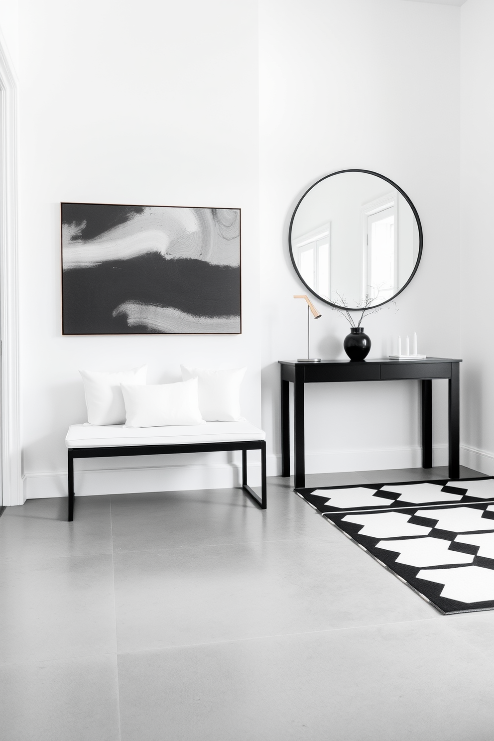 A minimalist black bench is positioned against a crisp white wall, adorned with plush white cushions for comfort. The floor is polished concrete, creating a sleek and modern contrast to the simplicity of the bench. The foyer features bold black and white geometric patterns on the floor, complemented by a striking black console table. Above the table, a large round mirror with a thin black frame reflects the light, enhancing the spacious feel of the area.