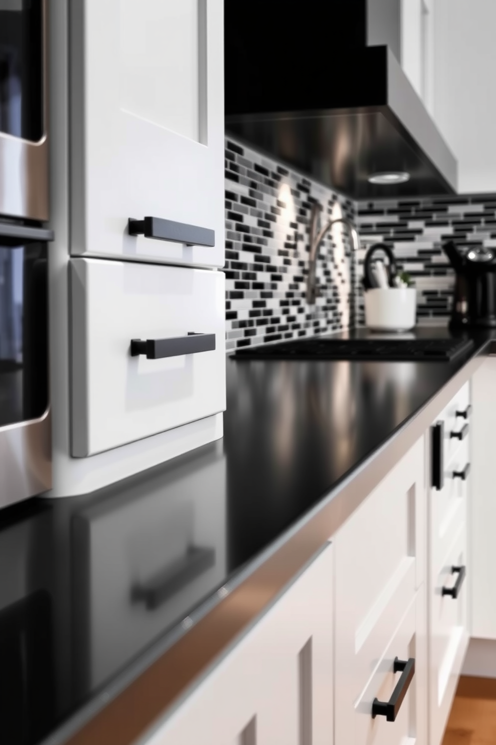 A modern kitchen featuring white drawers equipped with unique black hardware. The design incorporates sleek black countertops and a stylish backsplash for a striking black and white contrast.