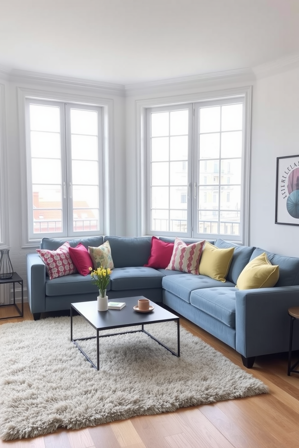 A muted blue sofa is positioned in the center of the living room, adorned with an array of colorful cushions that add a vibrant touch. The walls are painted in a soft white, creating a bright and airy atmosphere, while a stylish coffee table sits in front of the sofa, complementing the overall design. Large windows allow natural light to flood the space, enhancing the cheerful ambiance. A plush area rug in a neutral tone anchors the seating area, providing warmth and comfort to the blue apartment design.