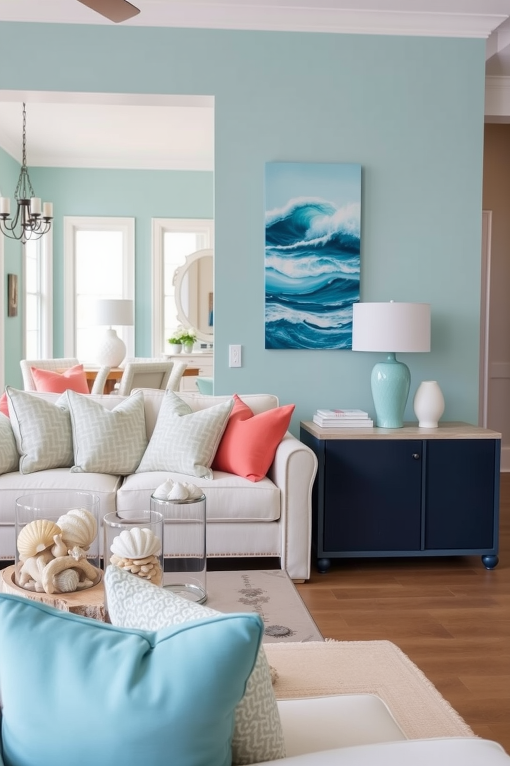 Ocean inspired decor with seashell accents. The walls are painted in a soft aqua hue, and the furniture features light, weathered wood finishes. The living area includes a plush white sofa adorned with throw pillows in shades of blue and coral. Decorative seashells are displayed in glass jars on a driftwood coffee table, creating a coastal ambiance. Blue apartment design ideas showcase an open floor plan with large windows allowing natural light to flood the space. A statement piece of art featuring ocean waves hangs above a sleek navy console table in the entryway.