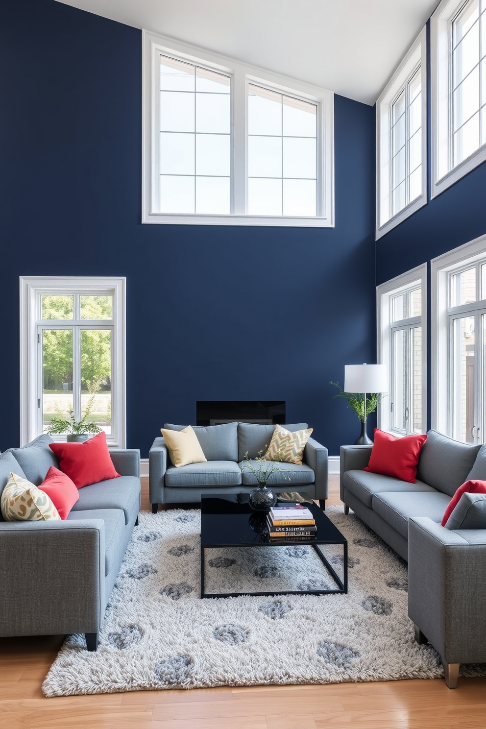 Navy blue feature wall with white trim creates a striking contrast in the living space. The room is filled with modern furniture in shades of gray and accented with vibrant throw pillows. Large windows allow natural light to flood the room, enhancing the rich tones of the navy wall. A sleek coffee table sits on a plush area rug, adding warmth to the contemporary design.