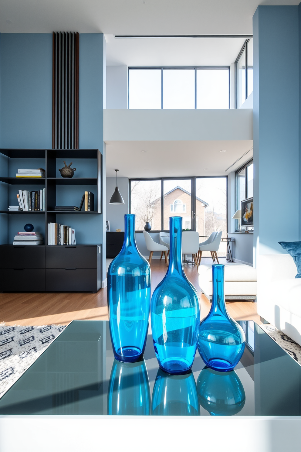 A modern living room with blue glass vases as decorative accents. The vases are strategically placed on a sleek coffee table and a stylish bookshelf, adding a pop of color to the space. The apartment features an open floor plan with soft blue walls and contemporary furniture. Large windows allow natural light to fill the room, enhancing the serene atmosphere.