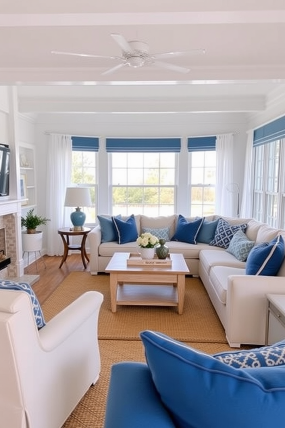 A cozy family room featuring coastal blue accents and crisp white trim. The walls are painted in a soft white, while the furniture showcases various shades of blue, including a plush sectional sofa and decorative throw pillows. Natural light floods the space through large windows adorned with sheer white curtains. A light wooden coffee table sits in the center, complemented by a woven area rug that adds warmth and texture to the room.