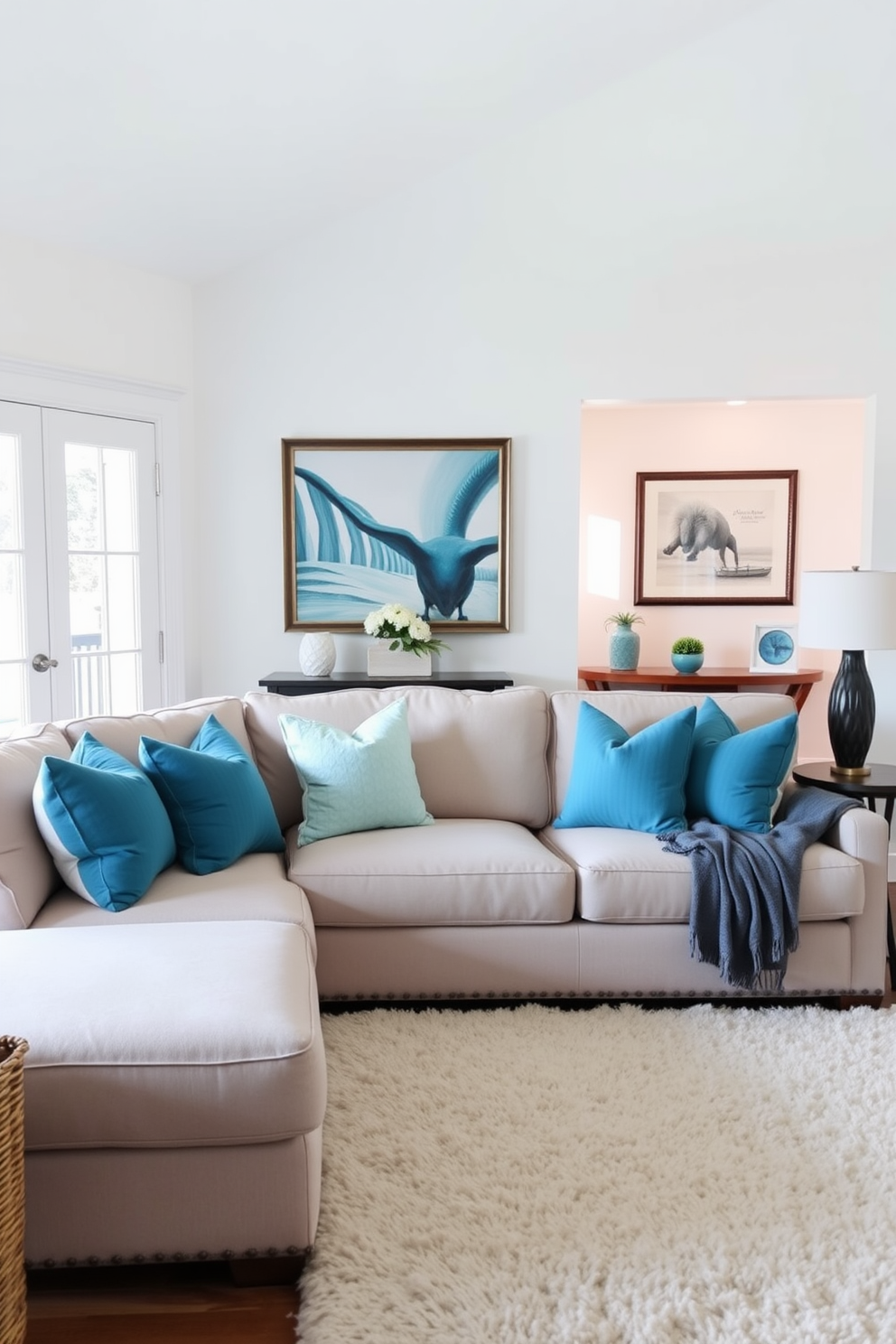 A cozy family room featuring a large sectional sofa adorned with aqua blue decorative pillows. The walls are painted in a soft white hue, and a plush area rug anchors the seating area, creating an inviting atmosphere.