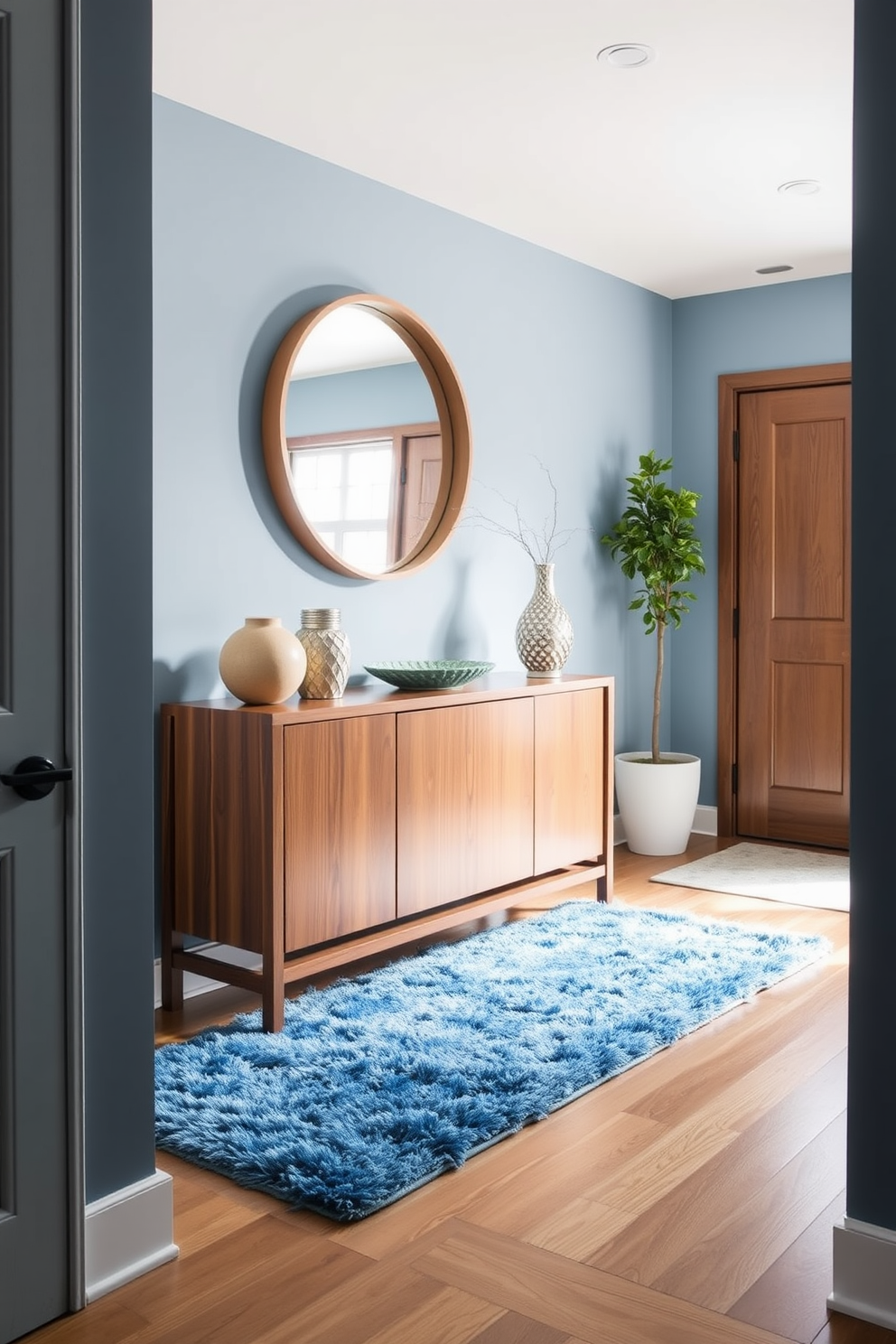 A serene foyer featuring muted blue decor complemented by earthy tones. The walls are painted in a soft blue hue, and a rustic wooden console table sits against one side, adorned with decorative elements in warm browns and greens.