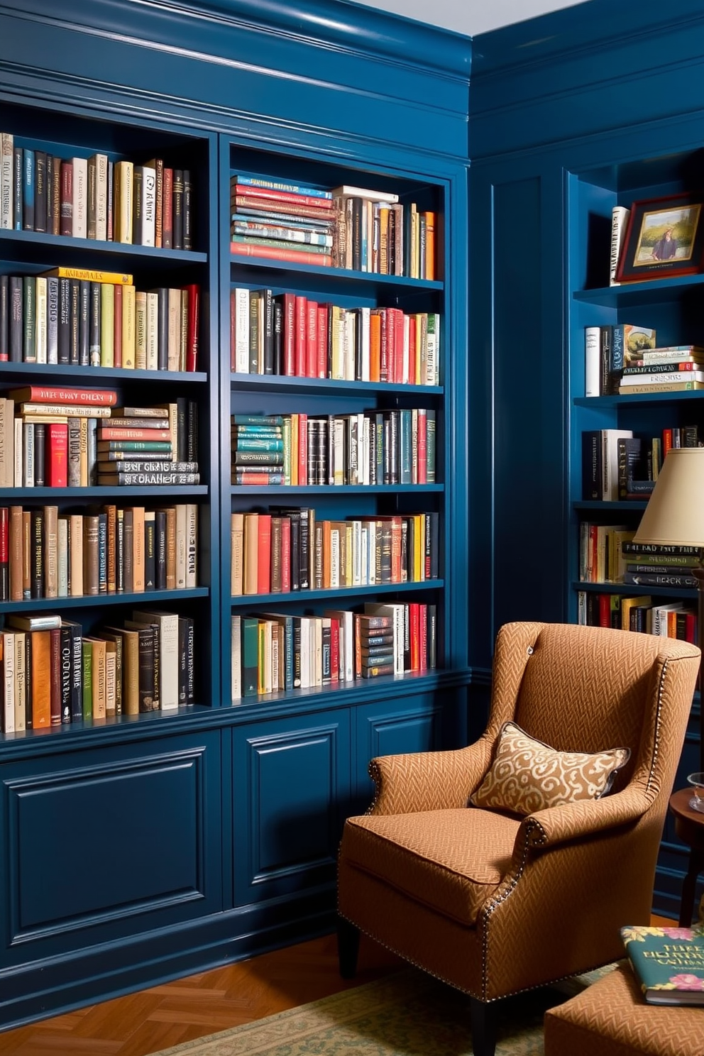 A cozy home library featuring built-in bookshelves painted in a rich blue hue. The shelves are filled with an assortment of books, and a comfortable reading nook is nestled in the corner with a plush armchair and a small side table.