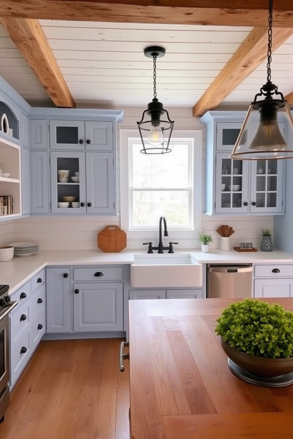 A charming farmhouse kitchen featuring soft blue accents throughout the space. The cabinetry is painted in a light blue hue, complemented by white shiplap walls and rustic wooden beams overhead. A large farmhouse sink sits beneath a window, surrounded by a mix of open shelving and closed cabinets. Vintage-inspired light fixtures hang above a spacious island, which is topped with a warm wood surface.