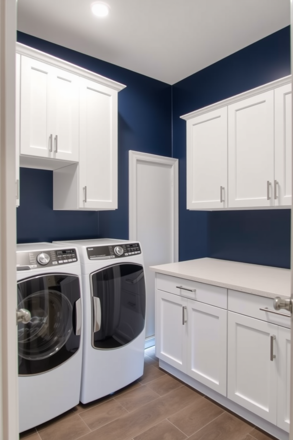 A serene laundry room featuring muted teal cabinets that seamlessly blend with open shelving. The space is illuminated by natural light streaming through a nearby window, highlighting the stylish organization of laundry essentials.