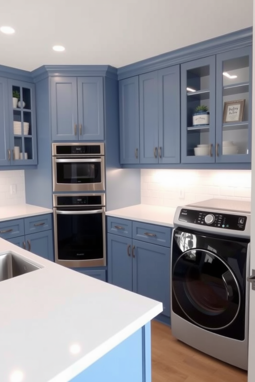 A laundry room with ocean blue tiles that create a fresh and inviting atmosphere. The space features white cabinetry with sleek handles and a large farmhouse sink beneath a window that lets in natural light. The countertops are made of light gray quartz, providing ample space for folding clothes. A stylish washing machine and dryer are seamlessly integrated into the cabinetry, enhancing the room's modern aesthetic.