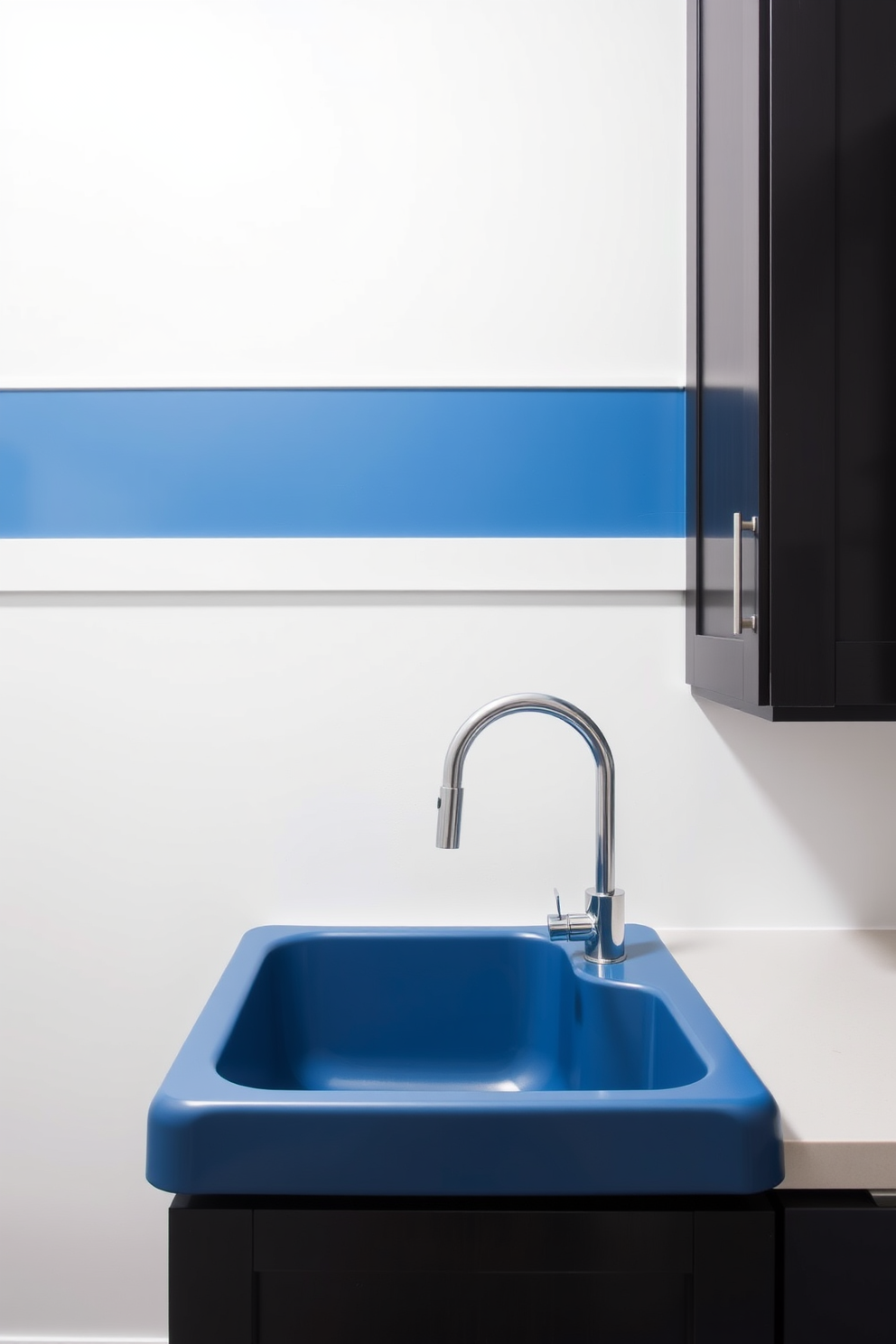 A stylish laundry room featuring a blue laundry sink equipped with a sleek modern faucet. The walls are painted in a soft white hue, complemented by dark cabinetry and a vibrant blue accent wall.