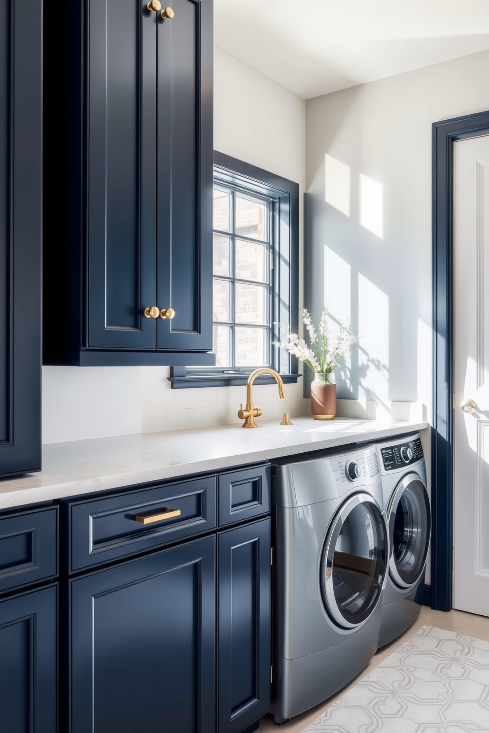 A stylish laundry room featuring dark blue cabinetry complemented by elegant brass hardware. The space is brightened by natural light streaming through a window, highlighting the rich tones of the cabinetry.