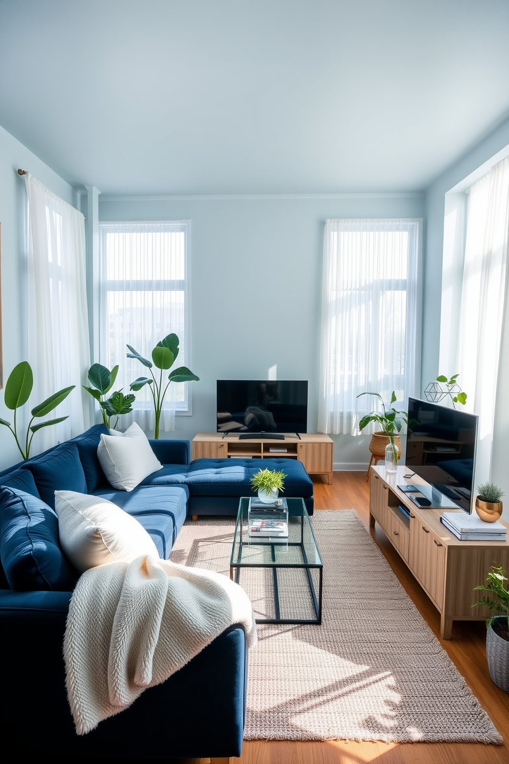 A light blue painted ceiling creates a sense of depth in the room. The living room features a plush sectional sofa in a deep navy hue, complemented by soft, oversized throw pillows in varying shades of blue and white. Natural light floods the space through large windows adorned with sheer white curtains. A sleek coffee table with a glass top sits atop a textured area rug, adding warmth to the cool color palette. An elegant entertainment unit in a light wood finish anchors the room, housing stylish decor and books. Potted plants in the corners bring a touch of nature indoors, enhancing the inviting atmosphere.