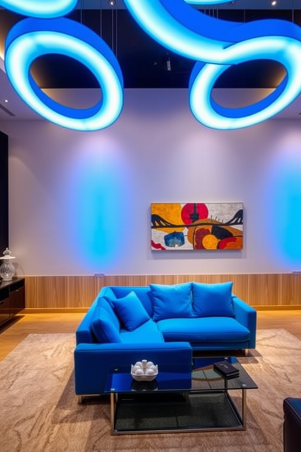 A contemporary living room featuring blue lighting fixtures overhead that create a vibrant atmosphere. The furniture includes a plush blue sectional sofa paired with a sleek glass coffee table, complemented by abstract art on the walls.