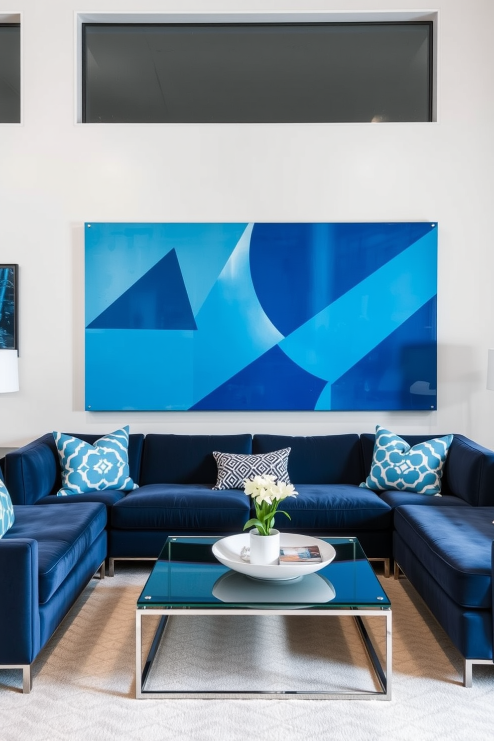 A modern living room featuring geometric blue wall art that adds a contemporary touch to the space. The room is designed with a plush navy sofa, accented by vibrant blue and white throw pillows, and a sleek glass coffee table in the center.