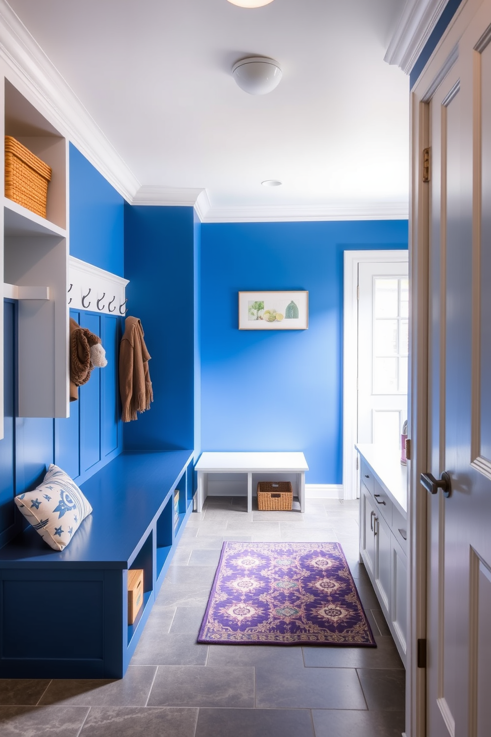 A stylish mudroom featuring blue and gray color-blocked walls that create a modern and inviting atmosphere. The space includes built-in storage benches with plush cushions and hooks for hanging jackets, complemented by a durable tile floor for easy maintenance.