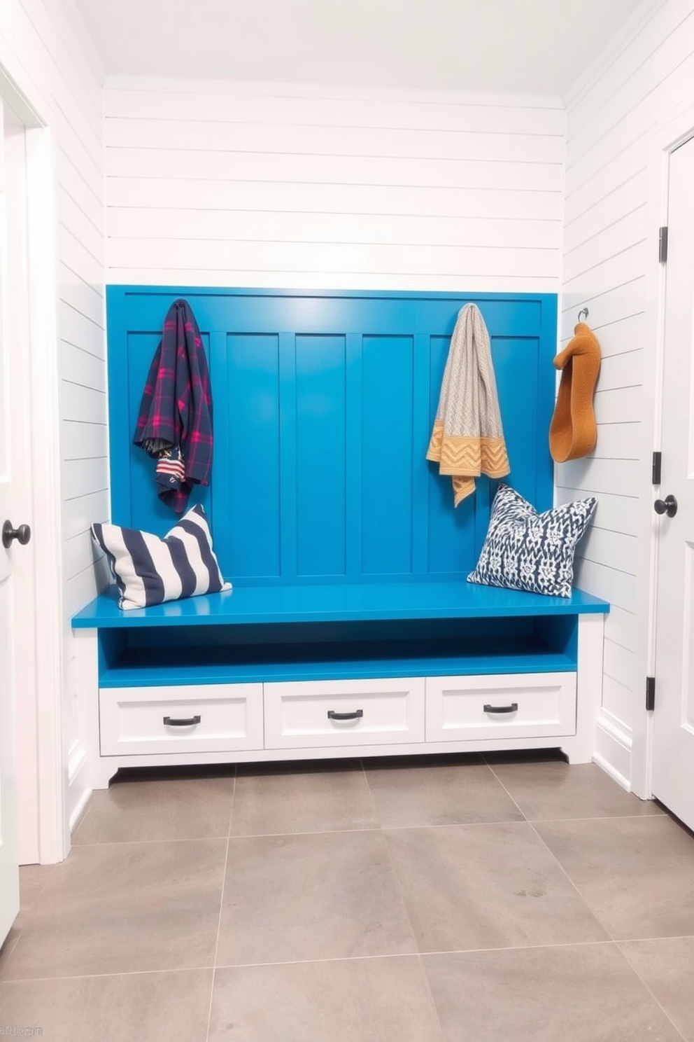 A cozy teal mudroom features natural wood accents throughout the space. The walls are painted in a rich teal hue, complemented by a wooden bench and open shelving for storage. The floor is adorned with durable tiles that mimic the look of natural stone. A woven basket sits beside the bench, and hooks are mounted on the wall for hanging coats and bags.