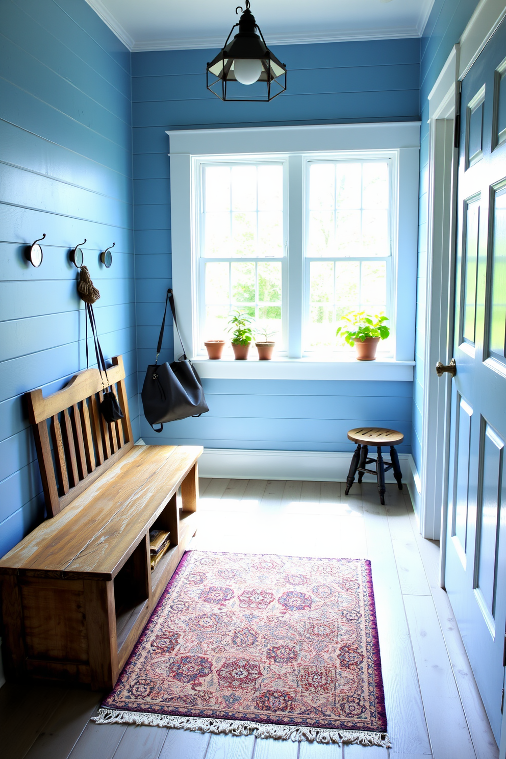 A serene mudroom featuring a muted blue color scheme that promotes tranquility. The walls are painted in a soft blue hue, complemented by white trim and a bench with plush cushions in coordinating shades. Storage solutions include built-in cabinets and hooks for coats, all designed to maintain a clean and organized space. Natural light floods in through a large window, enhancing the calming atmosphere and showcasing decorative elements like potted plants and textured rugs.