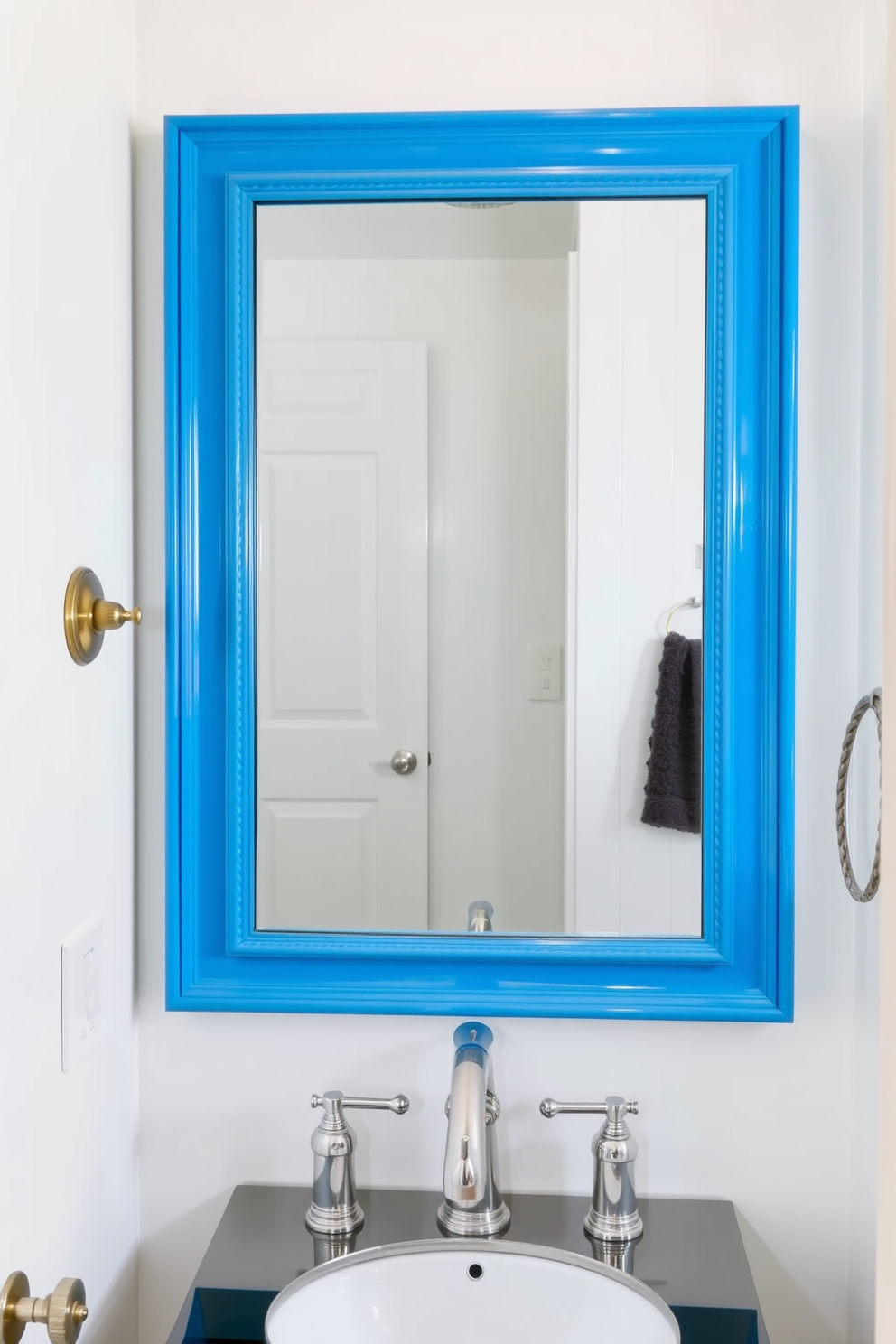 A chic powder room featuring a cerulean blue framed mirror that serves as a striking focal point. The walls are adorned with soft white paint, complemented by elegant fixtures and a stylish vanity with a polished chrome finish.