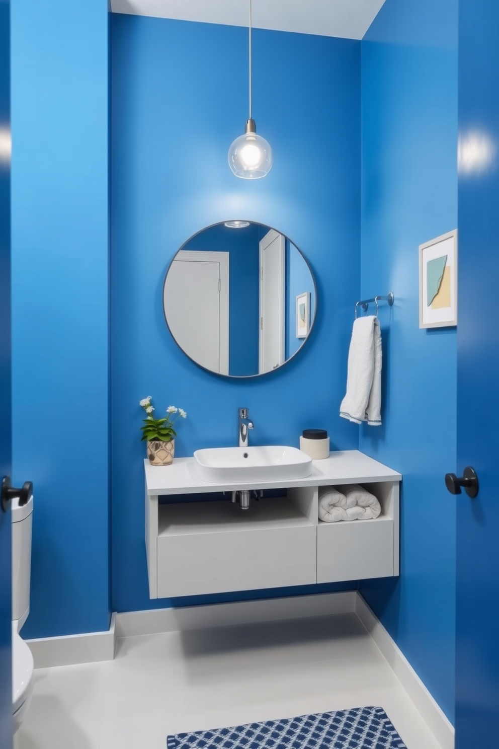 A stylish powder room features electric blue walls that create a vibrant backdrop. The decor is minimalist, showcasing a sleek floating vanity with a simple white sink and a large round mirror above it. The space is accented with a few carefully chosen decorative items, such as a small potted plant and a geometric wall art piece. A modern light fixture illuminates the room, enhancing the bold color and clean lines of the design.