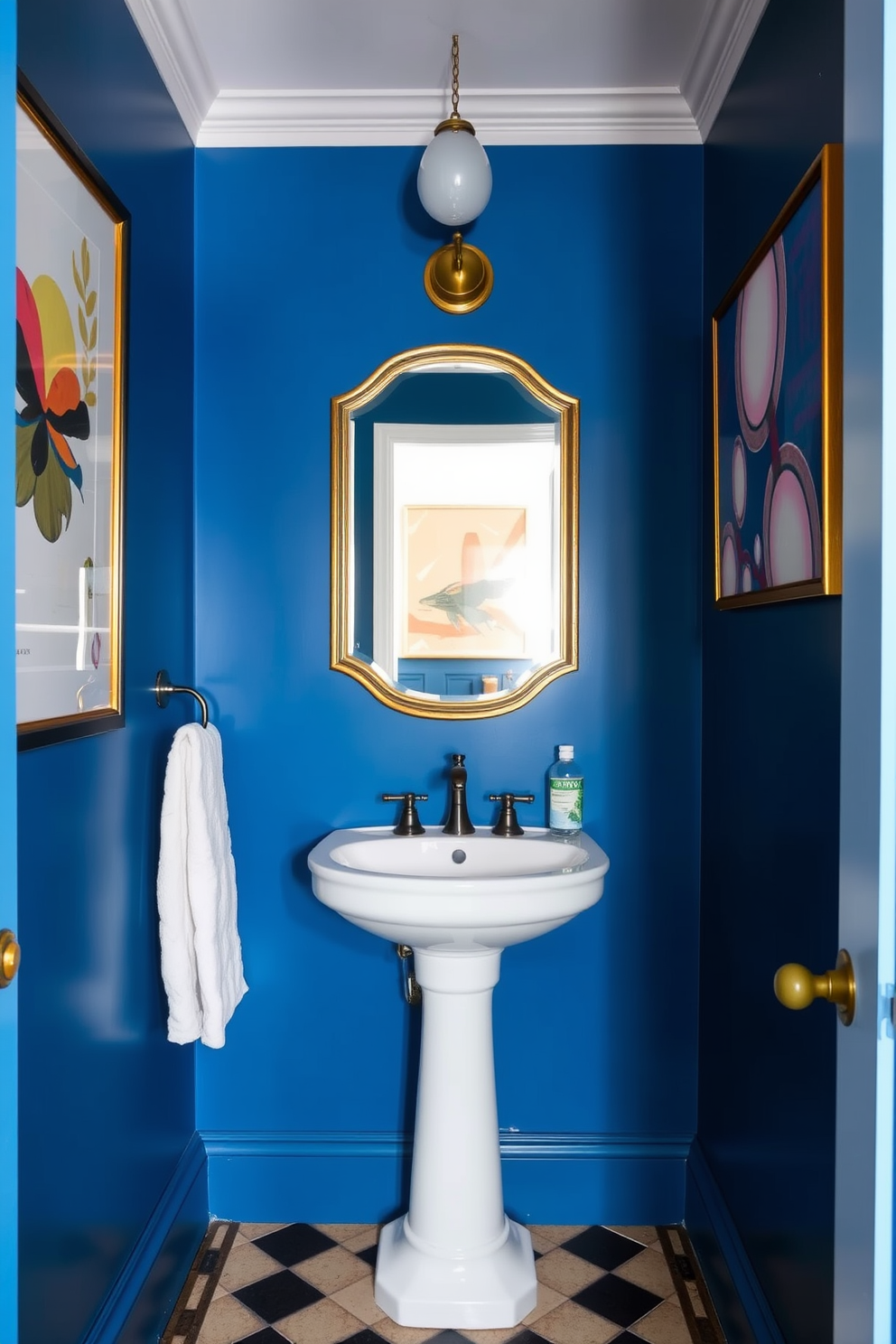 A rich blue powder room featuring contemporary art on the walls. The space is adorned with a sleek white pedestal sink and a gold-framed mirror that reflects the vibrant colors.