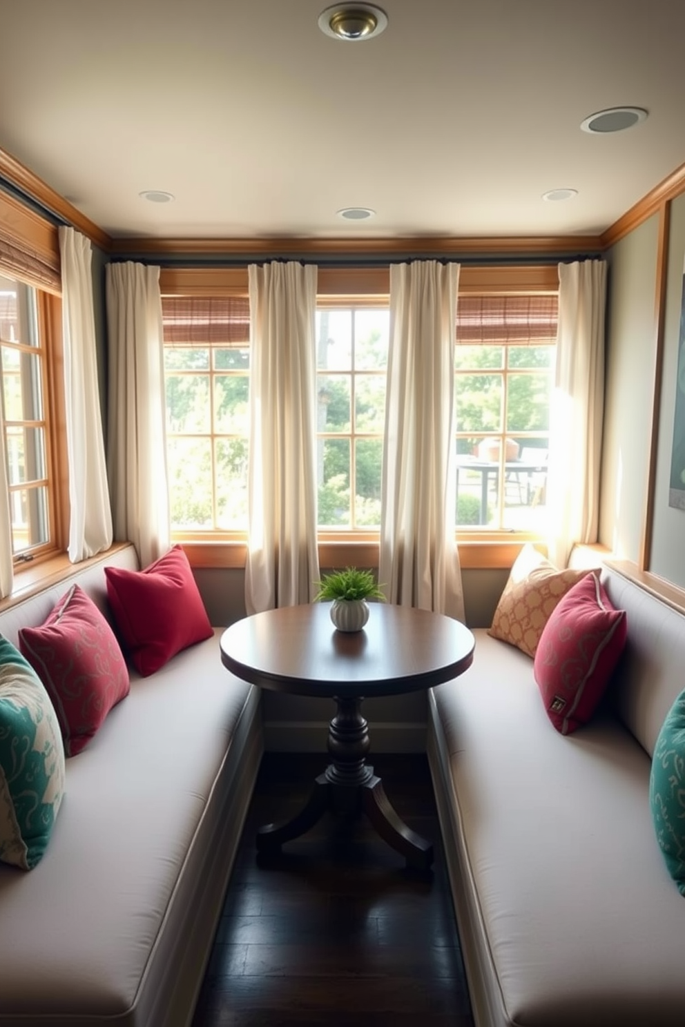 A cozy corner features built-in bench seating upholstered in soft fabric with colorful throw pillows. A round wooden table sits in the center, surrounded by natural light streaming in from large windows adorned with light curtains.