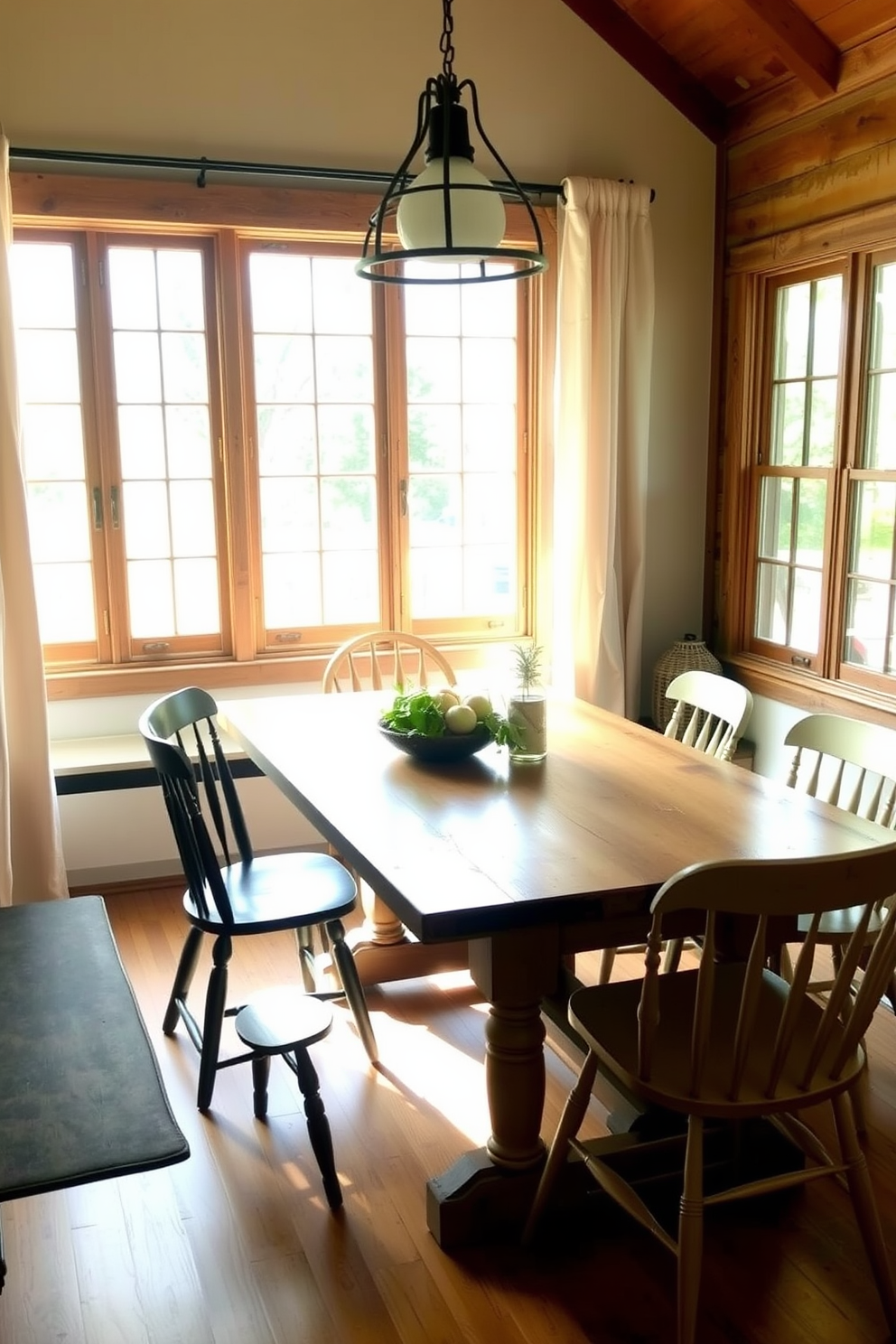 A rustic farmhouse table sits at the center of a cozy breakfast nook surrounded by mismatched chairs that add character and charm. Natural light pours in through large windows adorned with simple linen curtains, illuminating the warm wooden tones and inviting atmosphere.