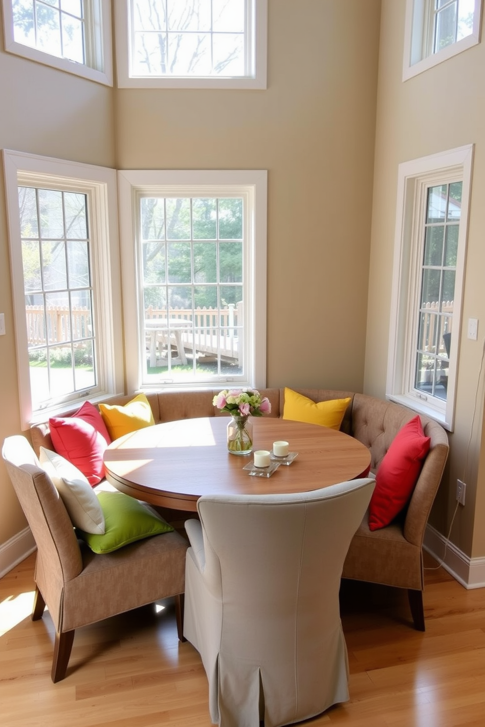 A cozy family-friendly nook featuring a round wooden table surrounded by upholstered chairs with durable fabrics. The walls are painted in a soft beige tone, and large windows allow natural light to fill the space, creating a warm and inviting atmosphere. Brightly colored cushions add a playful touch to the seating, while a simple centerpiece of fresh flowers sits on the table. The flooring is a light hardwood that complements the overall design, making it perfect for family gatherings and casual meals.