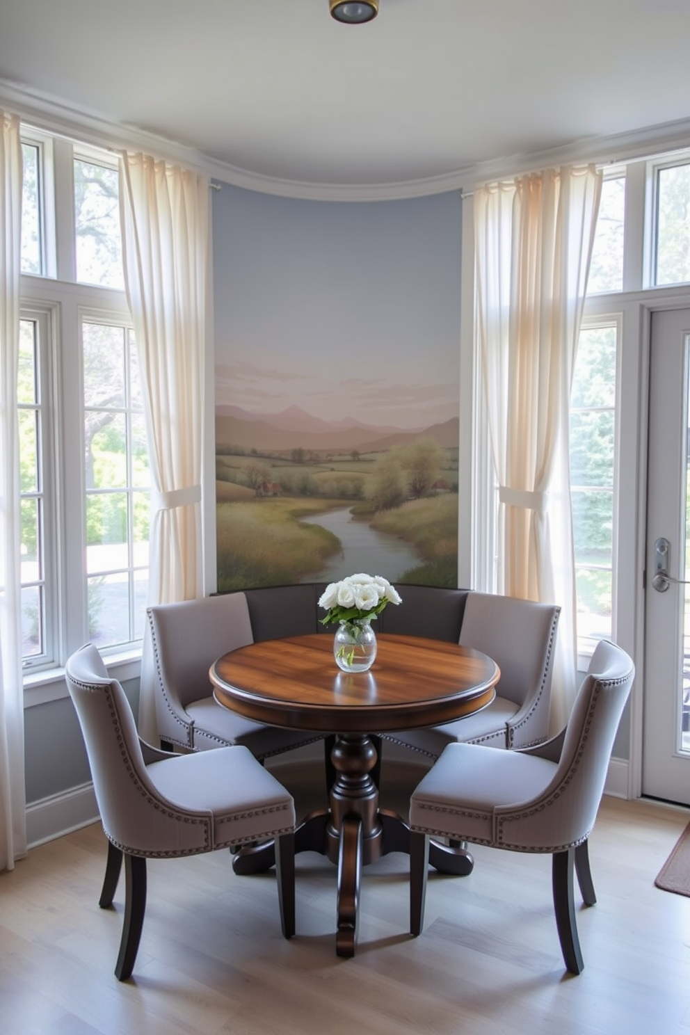 A cozy breakfast nook featuring an artistic mural as a focal point. The mural depicts a serene landscape with soft colors that complement the surrounding decor. A round wooden table sits at the center, surrounded by upholstered chairs in a contrasting fabric. Natural light floods the space through large windows adorned with sheer curtains, enhancing the inviting atmosphere.