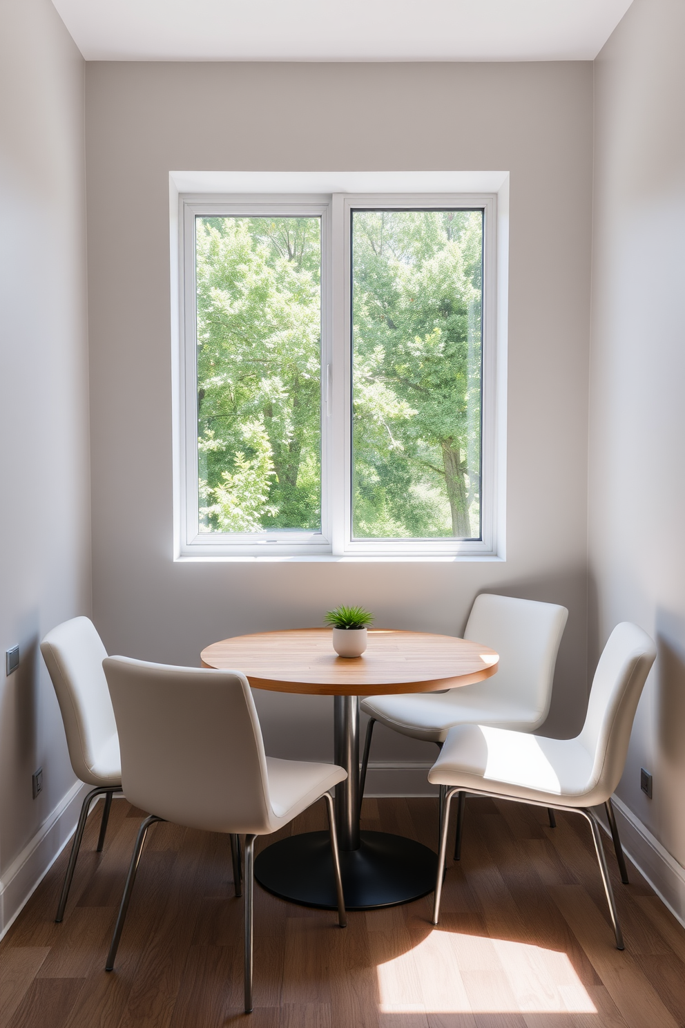 A minimalist nook featuring sleek modern furniture. The space includes a round wooden table surrounded by four white upholstered chairs, with a large window allowing natural light to flood in. The walls are painted in a soft gray, creating a calm atmosphere. A small potted plant sits on the table, adding a touch of greenery to the design.