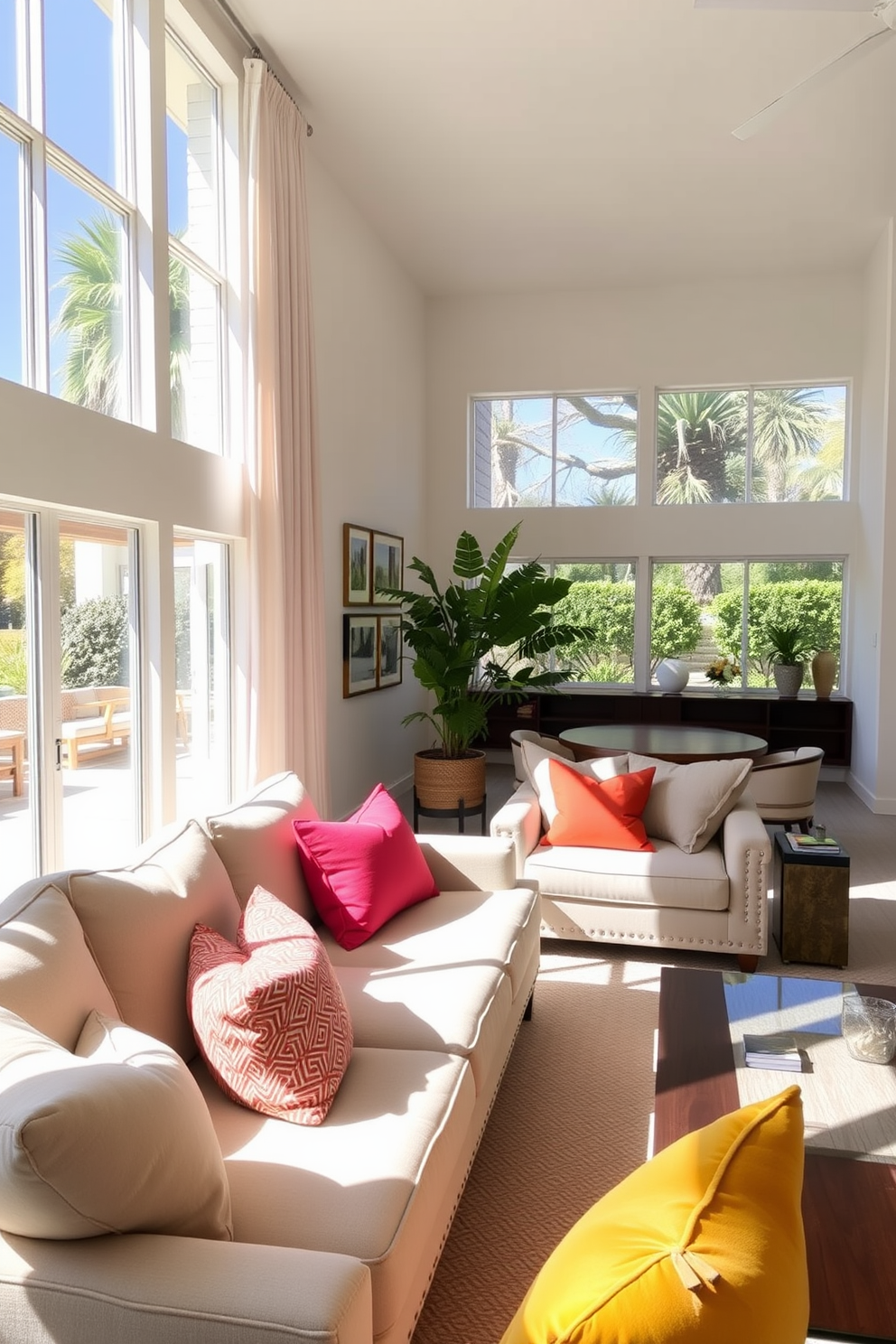 A spacious open concept living room filled with natural light from large floor-to-ceiling windows. The design features a blend of modern and coastal elements, with a light color palette and comfortable seating arrangements. A large sectional sofa in soft beige is complemented by a pair of accent chairs in ocean blue. A wooden coffee table sits at the center, surrounded by decorative cushions and a vibrant area rug that adds warmth to the space.