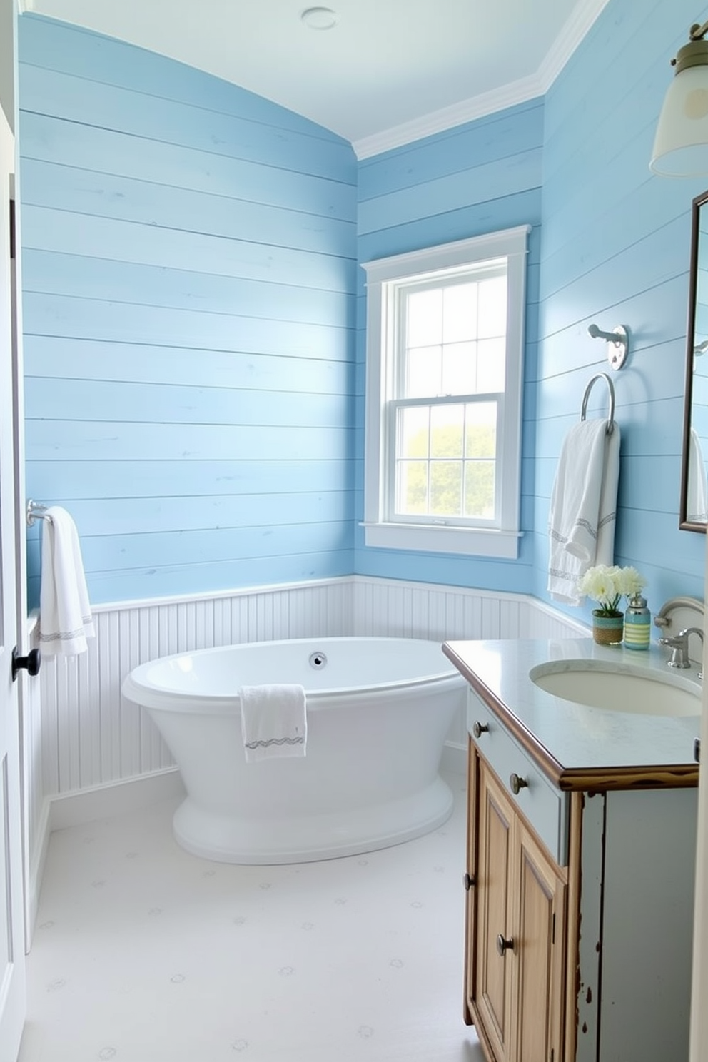 A coastal bathroom design featuring light blue shiplap wall accents creates a serene and inviting atmosphere. The space includes a freestanding soaking tub positioned under a large window, allowing natural light to fill the room. Complementing the shiplap, white beadboard wainscoting adds texture and charm to the lower walls. A rustic wooden vanity with a white countertop and nautical-themed accessories enhances the coastal vibe.