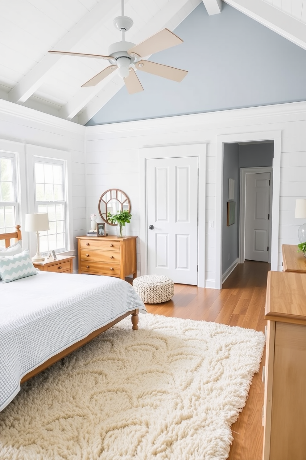 A serene coastal bedroom featuring a soft area rug that adds warmth and comfort to the space. The walls are painted in a light blue hue, complemented by white shiplap accents and natural wood furniture.