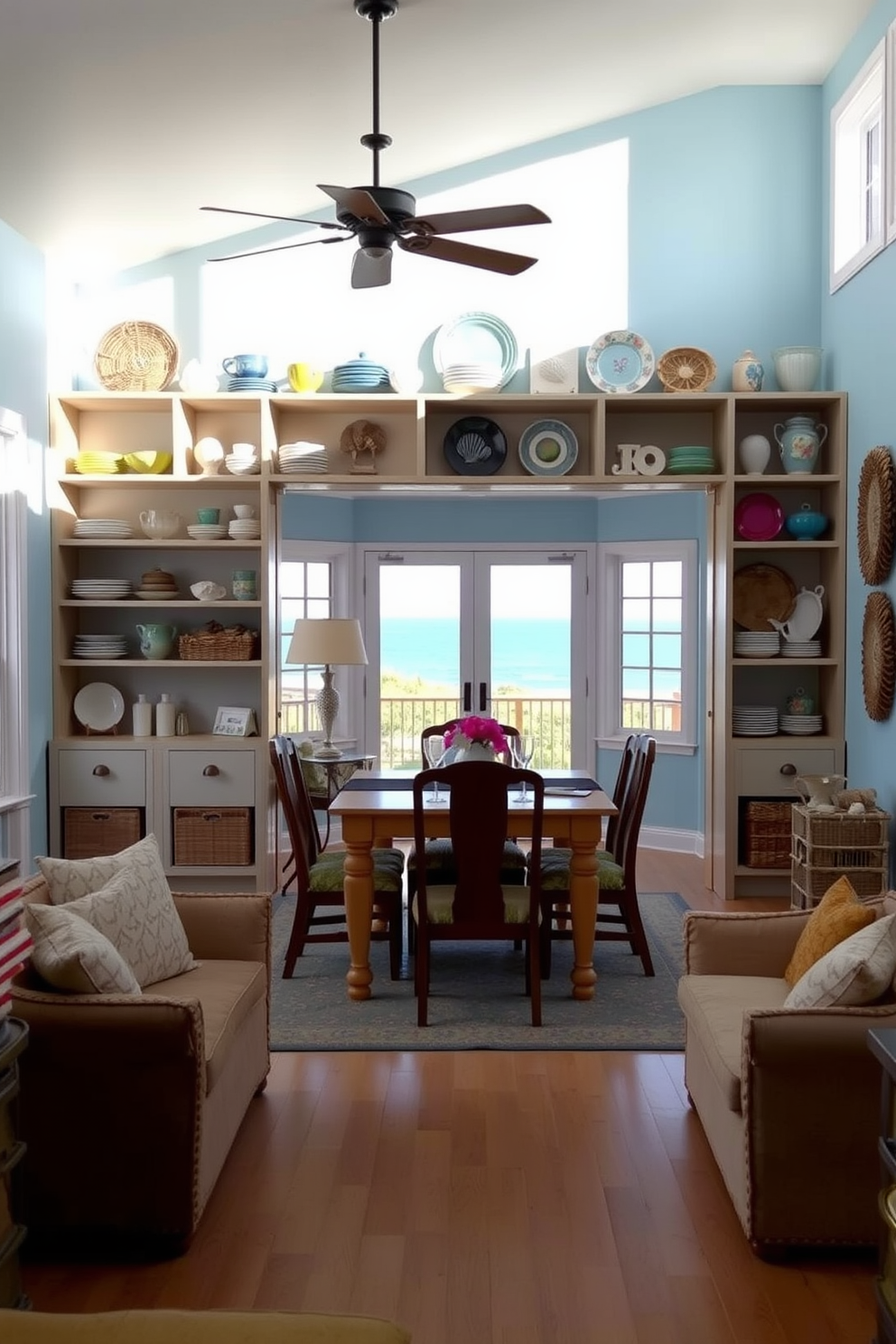 Open shelving displays an array of decorative dishware, featuring a mix of vibrant colors and textures that enhance the coastal theme. The dining room is bathed in natural light, with soft blue walls and a light wood dining table surrounded by comfortable seating. The decor includes seashell accents and woven baskets, adding a touch of beach-inspired charm. A large window overlooks a scenic view, bringing the essence of the coast indoors.