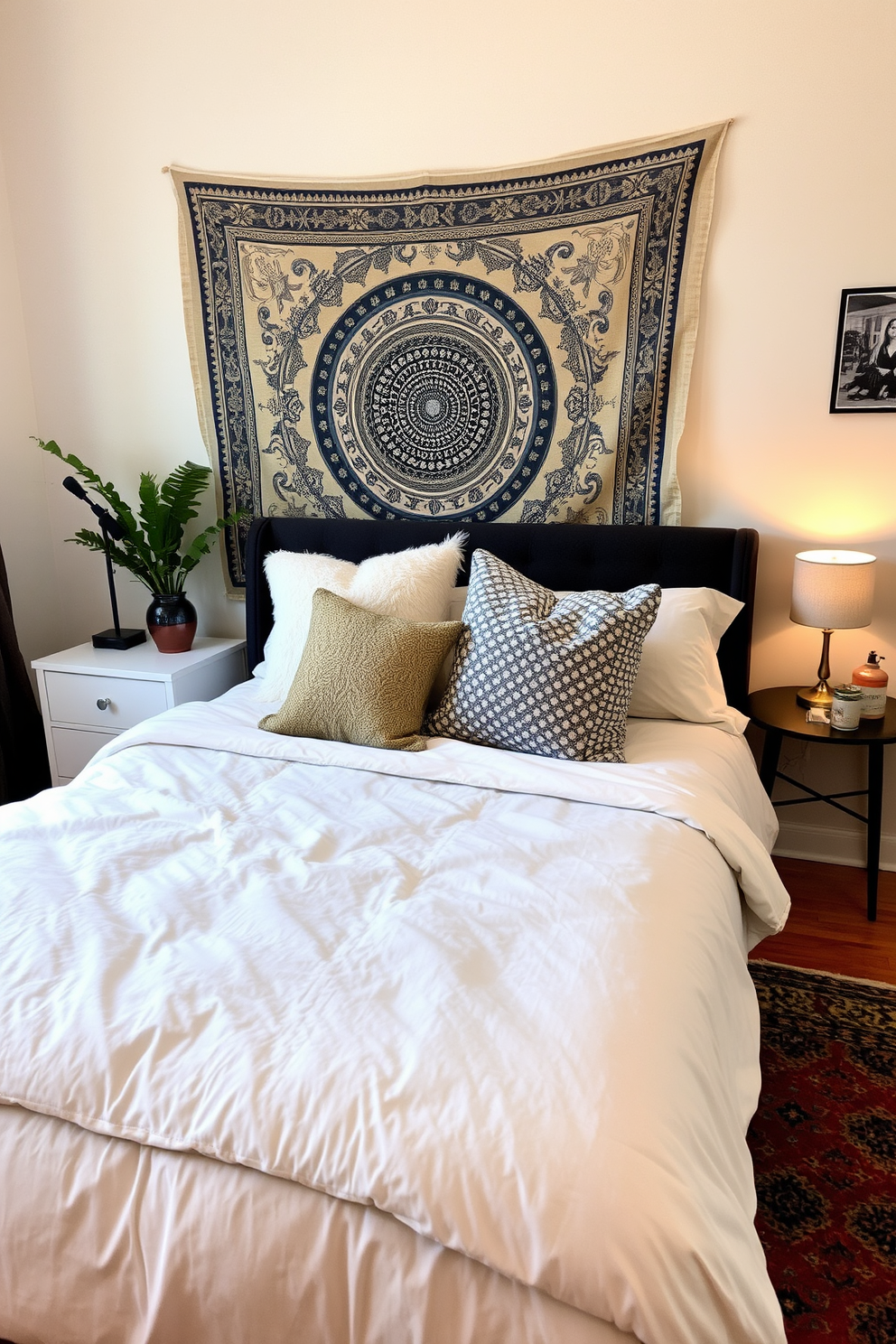 Layered bedding creates a cozy and inviting atmosphere in a college apartment bedroom. The bed features a plush duvet in soft neutral tones, topped with an array of decorative pillows in varying textures and patterns. The wall behind the bed is adorned with a trendy tapestry, adding warmth and personality to the space. A small bedside table holds a stylish lamp and a few personal items, while a colorful area rug anchors the room and adds comfort underfoot.