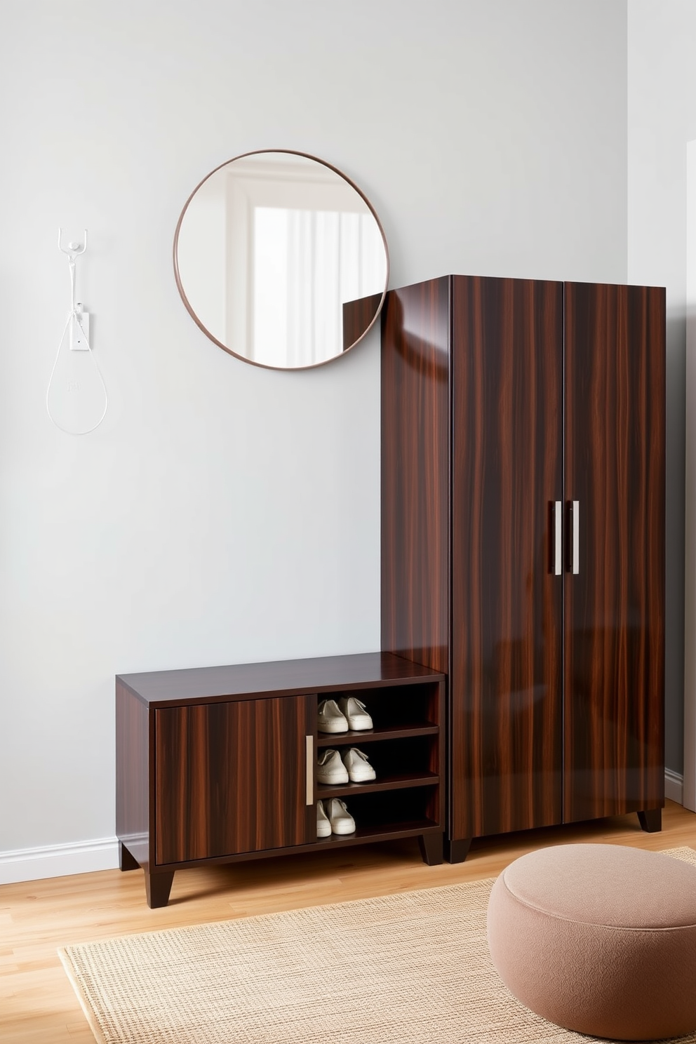 A stylish condo entryway featuring a sleek shoe storage cabinet made of dark wood with a glossy finish. The cabinet is positioned against a light gray wall, complemented by a round mirror above it that enhances the space's brightness. To the side of the cabinet, a small bench with soft cushions provides a comfortable spot to sit while putting on shoes. The floor is adorned with a warm-toned area rug that adds texture and invites guests into the home.