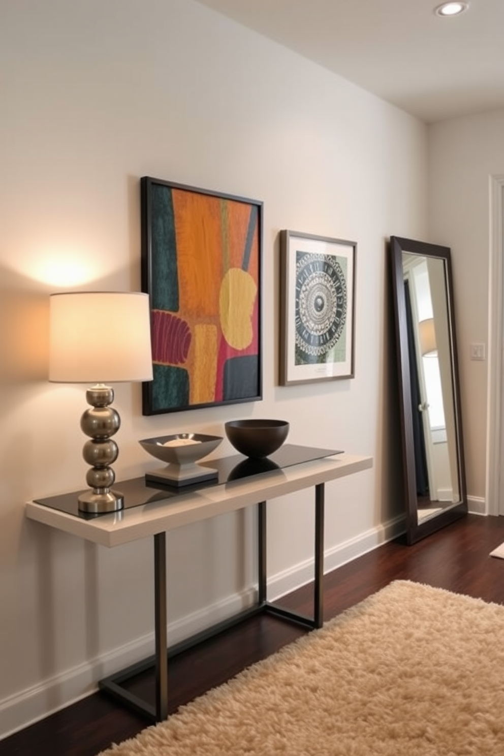 A stylish condo entryway featuring a sleek console table with a modern lamp and a decorative bowl. The walls are adorned with framed artwork that showcases vibrant colors and unique patterns, creating an inviting atmosphere. To the right of the console, a full-length mirror with a minimalist frame enhances the sense of space. A plush area rug in neutral tones lies beneath, adding warmth and texture to the entryway.