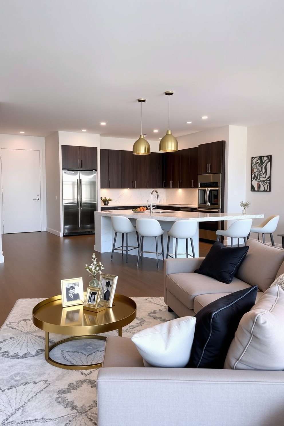 A contemporary apartment living room features sleek furniture with clean lines and a neutral color palette. Metallic finishes are incorporated through decorative accents like a gold coffee table and silver picture frames, enhancing the elegance of the space. The open kitchen design showcases stainless steel appliances and a marble island with bar seating. Pendant lights with metallic shades hang above, creating a stylish focal point while maintaining a modern aesthetic.