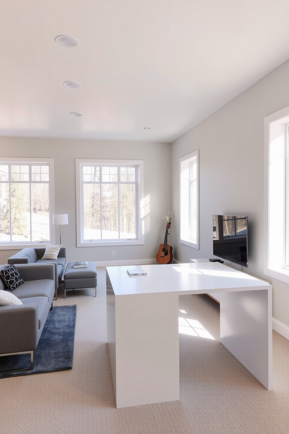 Bright workspace with large windows. The room features a sleek white desk positioned in front of the windows, allowing natural light to flood the space. Contemporary basement design ideas. The area includes a comfortable lounge with a sectional sofa, a modern coffee table, and an entertainment unit against the wall.