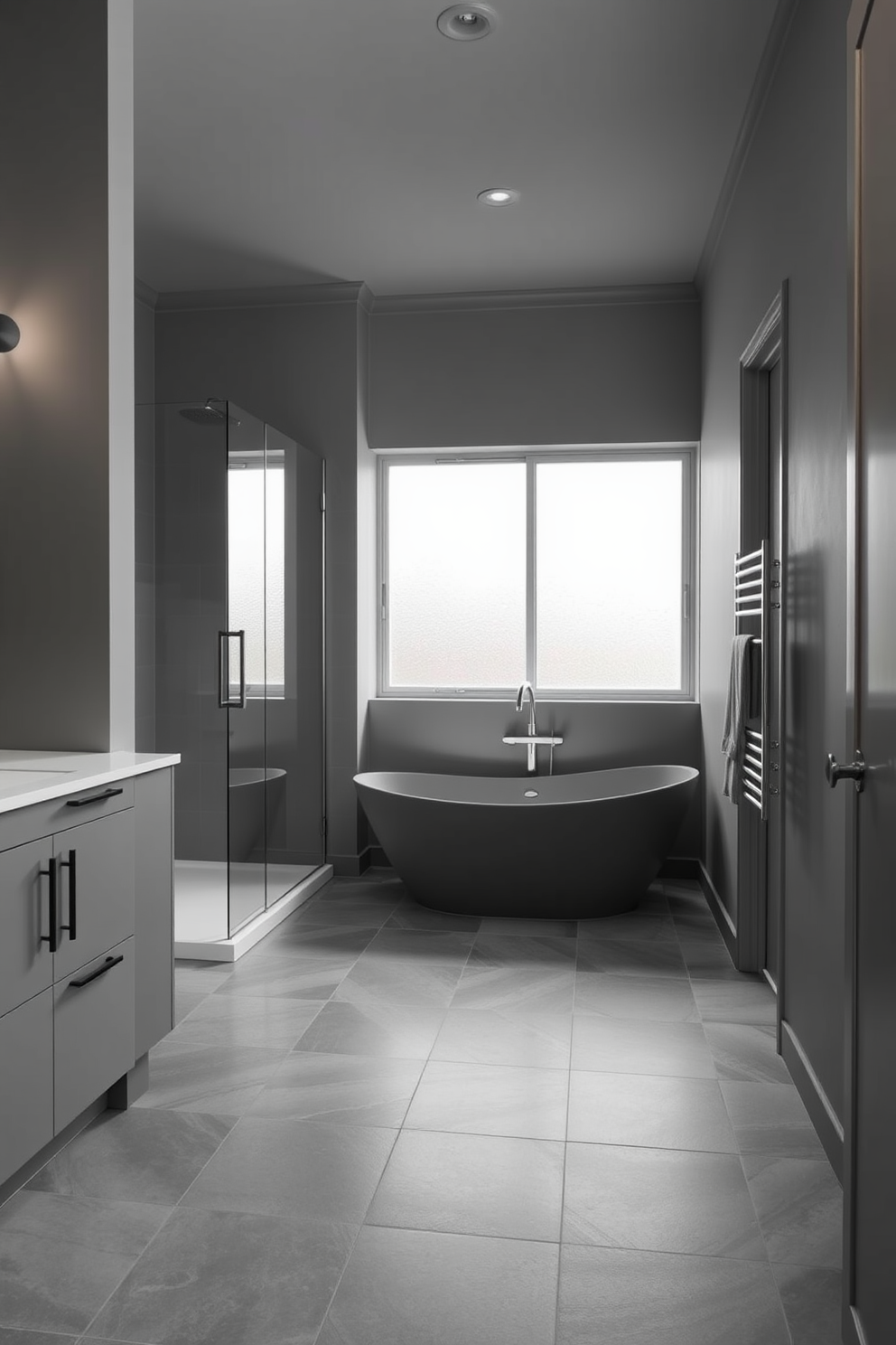 A contemporary bathroom featuring a monochromatic color scheme. The walls are painted in varying shades of gray, complemented by sleek gray cabinetry and a minimalist shower enclosure. The floor is adorned with large gray tiles that create a seamless flow throughout the space. A freestanding soaking tub in the same tone sits elegantly under a frosted window, enhancing the serene atmosphere.