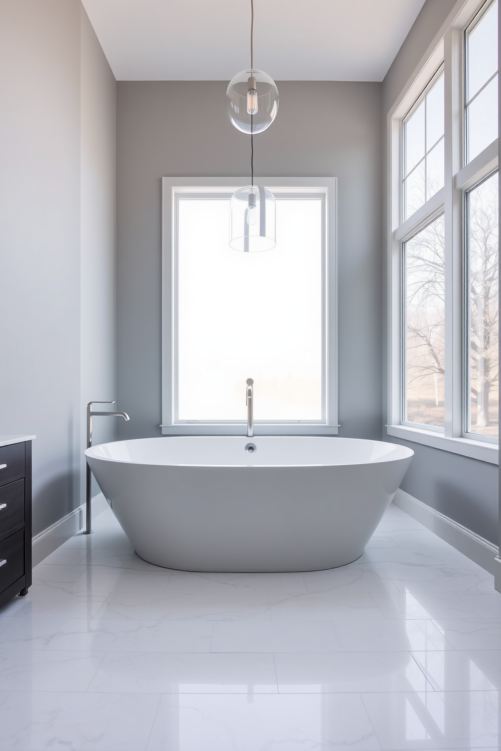 A contemporary bathroom features a freestanding bathtub as the focal point, elegantly positioned in the center of the room. The bathtub is surrounded by sleek marble tiles, with large windows allowing natural light to flood the space. The walls are painted in a soft gray hue, complementing the minimalist aesthetic. Modern fixtures in brushed nickel add a touch of sophistication, while a stylish pendant light hangs above the bathtub.