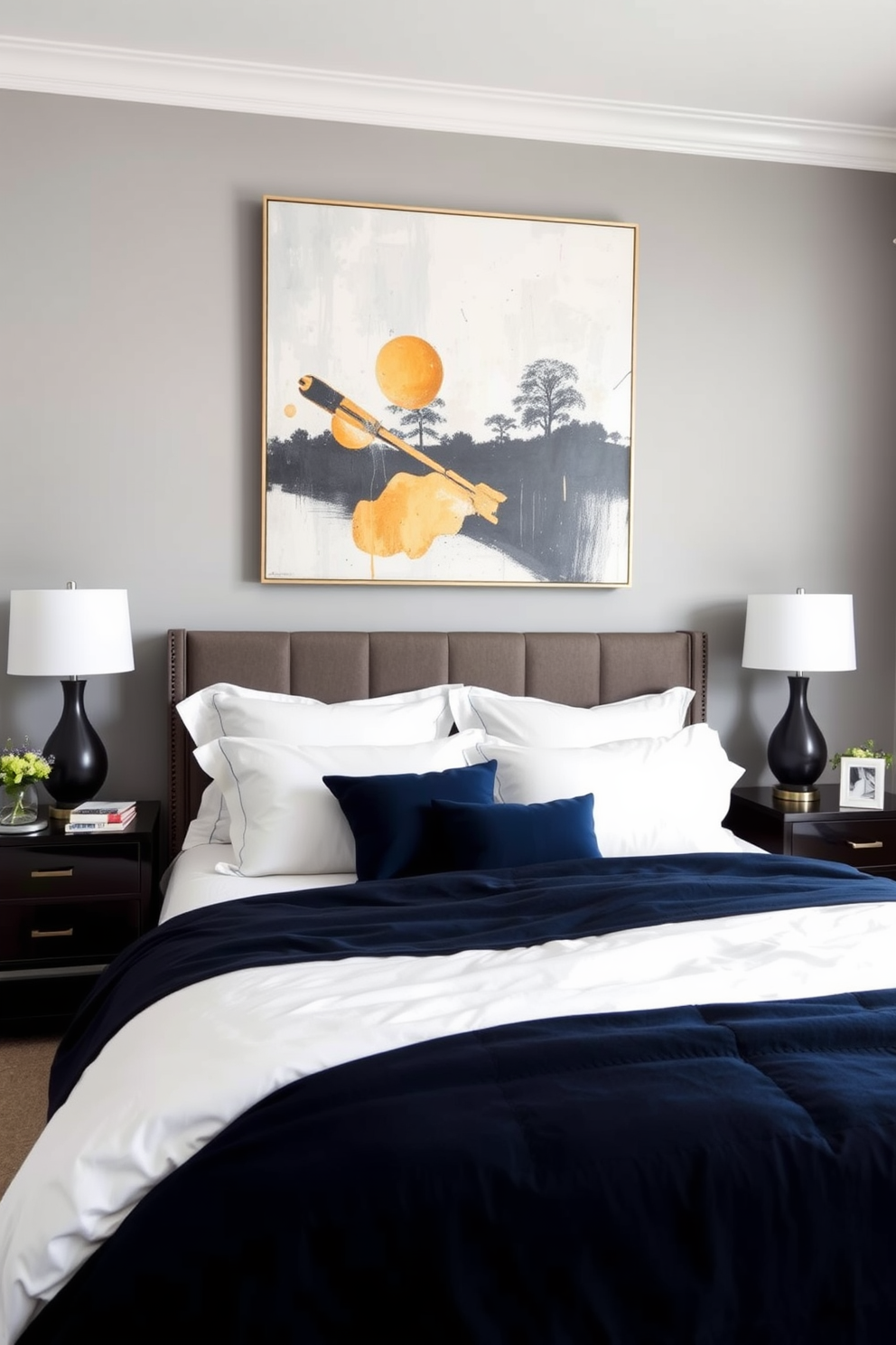 A contemporary bedroom featuring a large piece of abstract artwork as the focal point above the bed. The walls are painted in a soft gray tone, and the bedding is a mix of crisp white and deep navy blue for a modern contrast.