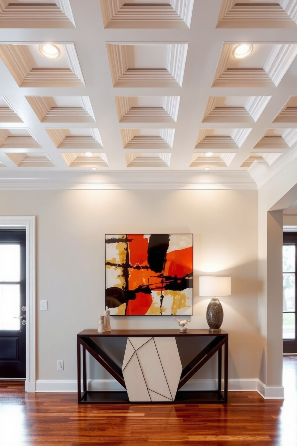 Artistic ceiling design for interest. A coffered ceiling with intricate molding details adds depth and character to the space while soft recessed lighting enhances the ambiance. Contemporary foyer design ideas. A sleek console table with a geometric design sits against the wall, accompanied by a large abstract artwork that serves as a focal point for the entrance.