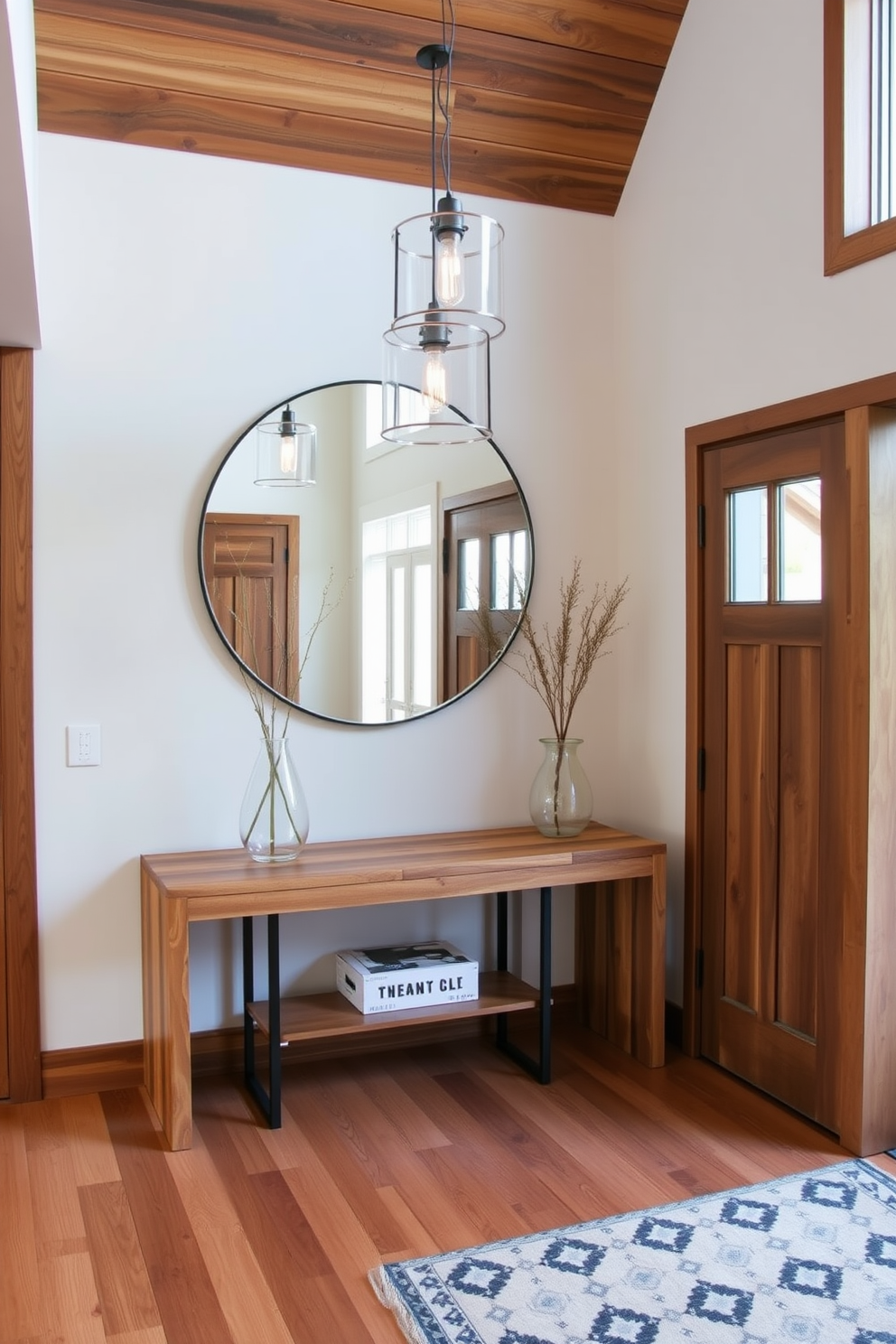 A contemporary foyer with natural wood accents creates a warm and inviting atmosphere. The space features a sleek console table made of reclaimed wood paired with a large round mirror that reflects light and enhances the sense of openness. Stylish pendant lighting hangs from the ceiling, casting a soft glow over the area. A patterned area rug lies beneath, adding texture and interest to the floor while complementing the wooden elements.