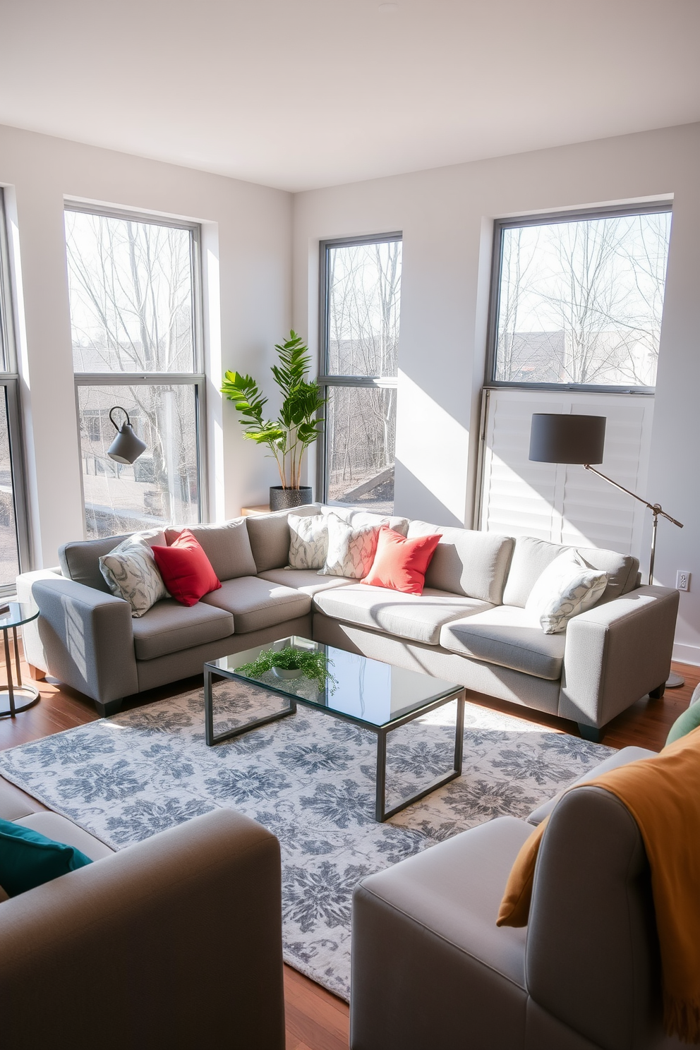 A comfortable sectional sofa is positioned in the center of a contemporary living room, inviting warmth and relaxation. The sofa is upholstered in a soft grey fabric, adorned with colorful throw pillows that add a pop of personality. Surrounding the sofa, a sleek coffee table made of glass and metal complements the modern aesthetic. Large windows allow natural light to flood the space, highlighting the minimalist decor and a stylish area rug beneath the seating arrangement.