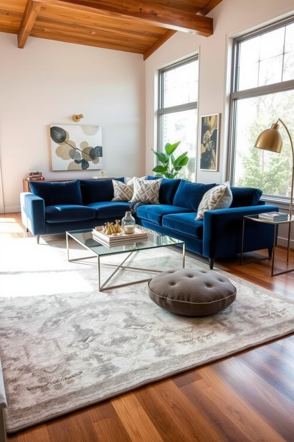 A contemporary living room featuring a plush velvet sofa in deep blue paired with a sleek glass coffee table. The walls are adorned with abstract art, and a soft area rug with geometric patterns anchors the space, creating a cozy yet modern atmosphere. Natural light floods the room through large windows, highlighting the mix of materials like polished wood, soft textiles, and metal accents. A stylish floor lamp and a collection of decorative pillows add layers of comfort and sophistication to the design.