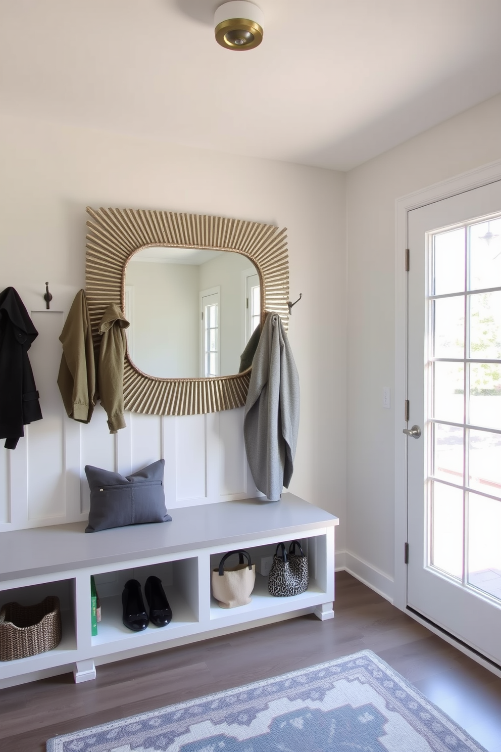 Bright lighting fixtures illuminate a spacious mudroom with sleek cabinetry and a built-in bench. The walls are painted in a soft gray, complemented by a durable, textured flooring that enhances functionality. Stylish hooks are mounted for easy access to coats and bags, while decorative baskets provide organized storage. A large window allows natural light to filter in, creating an inviting and airy atmosphere.