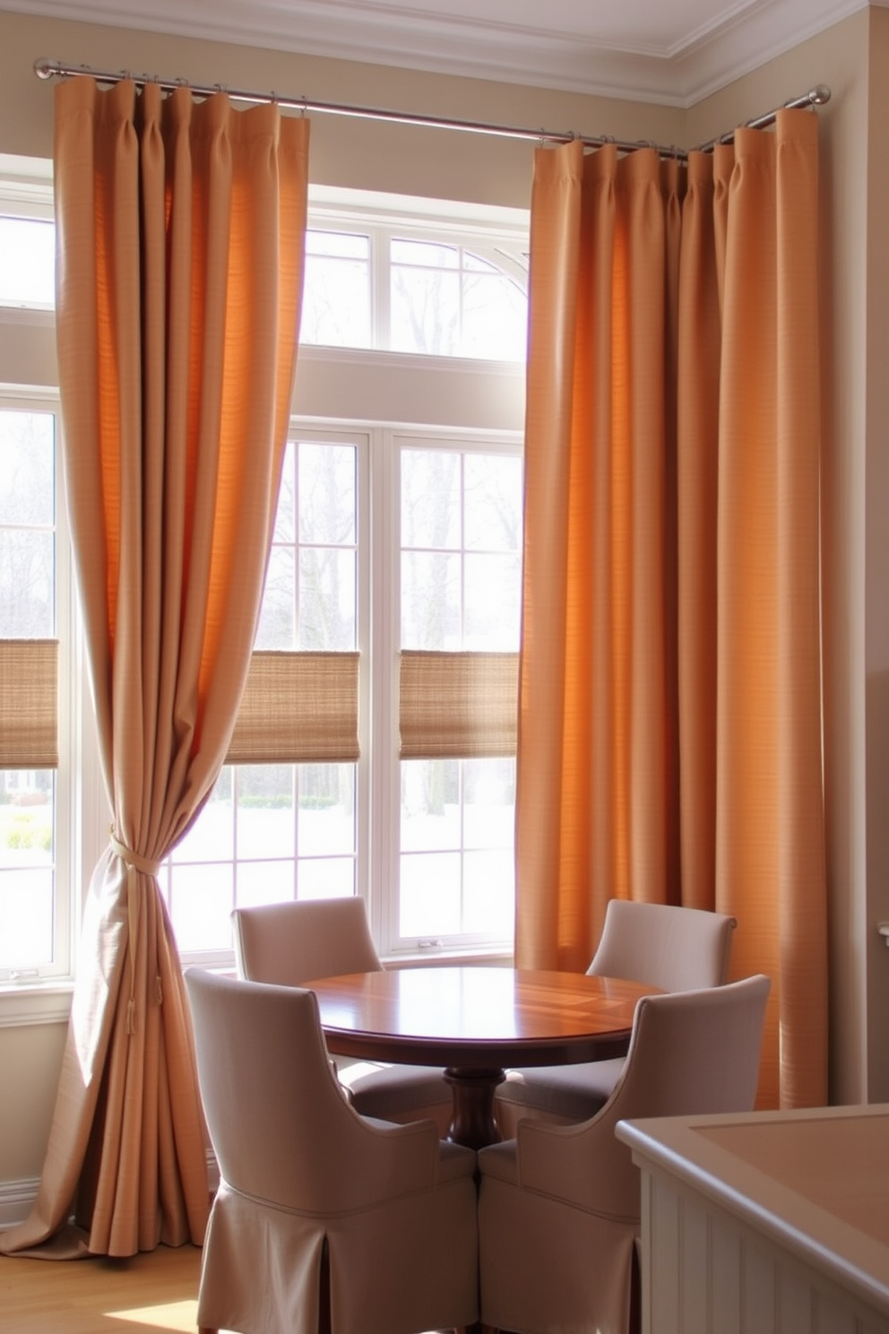 A cozy corner dining room featuring a round wooden table surrounded by upholstered chairs in a soft gray fabric. A small side table is positioned next to the table, providing convenience for drinks and appetizers. The walls are painted in a warm beige tone, enhancing the inviting atmosphere. Large windows allow natural light to fill the space, adorned with sheer white curtains that gently filter the sunlight.