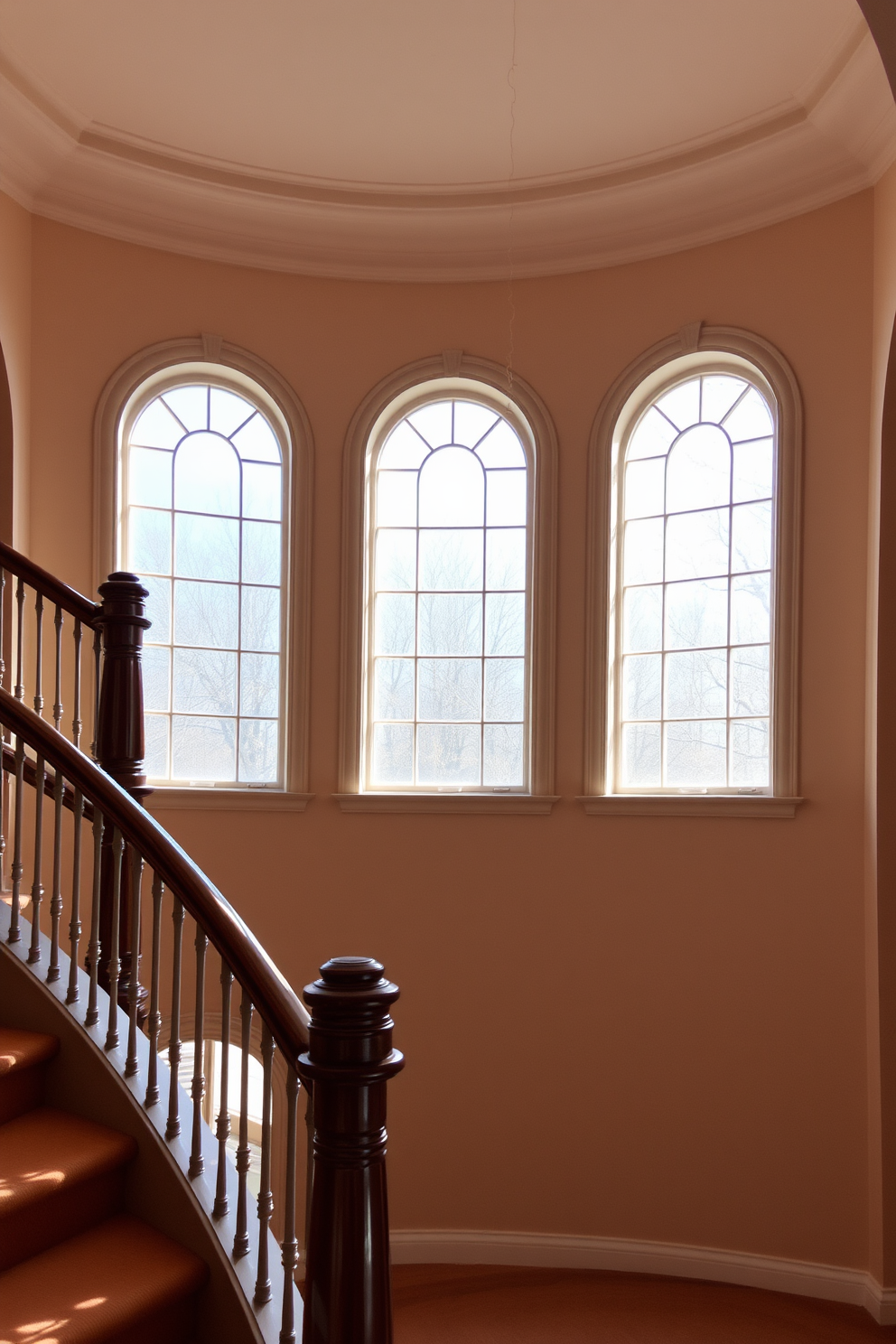 A grand staircase is highlighted by elegant arched windows that allow natural light to flood the space. The staircase features a curved design with a polished wooden handrail, creating a seamless flow from one level to another.