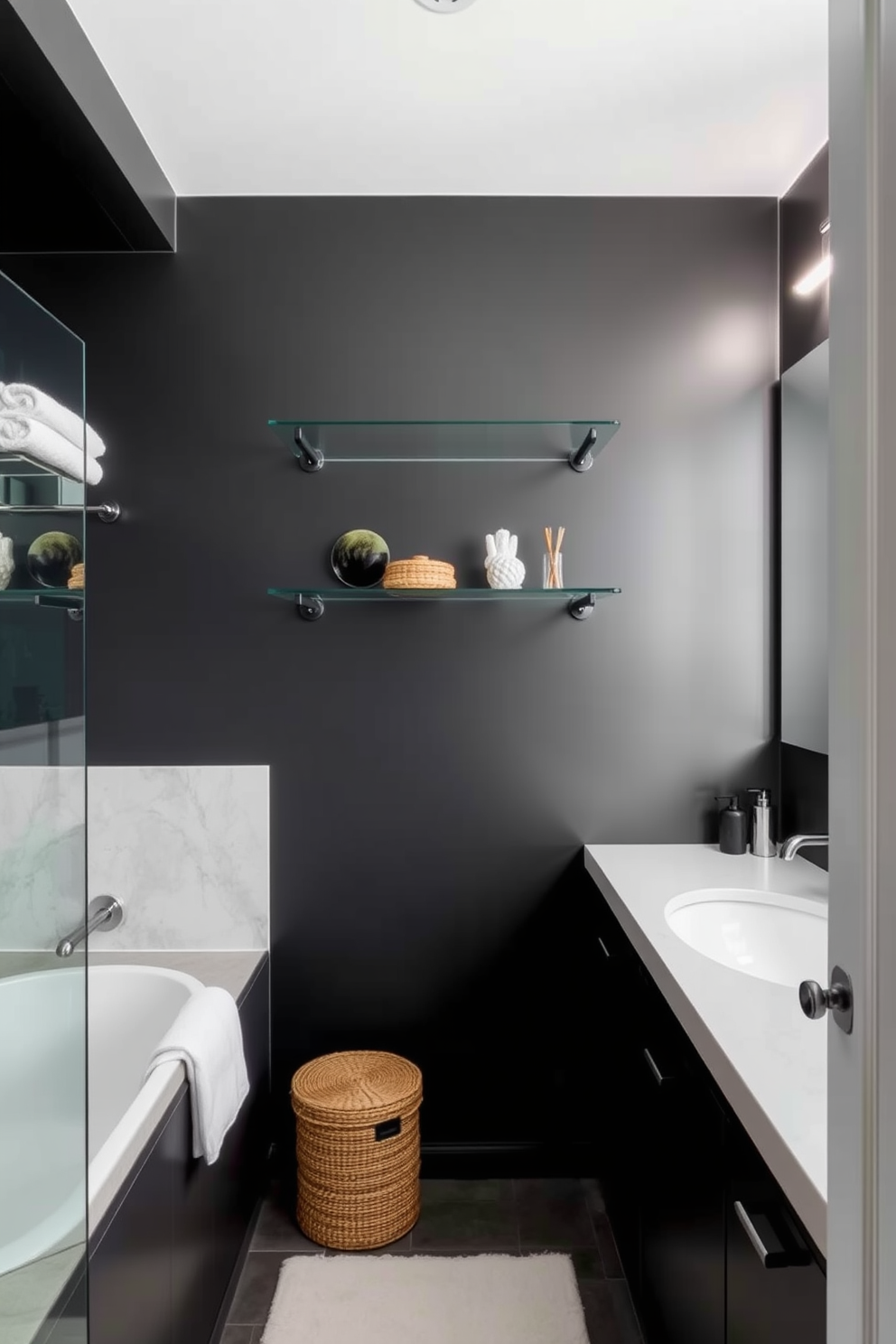 A sleek dark bathroom featuring glass shelves for a minimalist display. The walls are painted in a deep charcoal hue, creating a dramatic backdrop for the carefully curated decor.