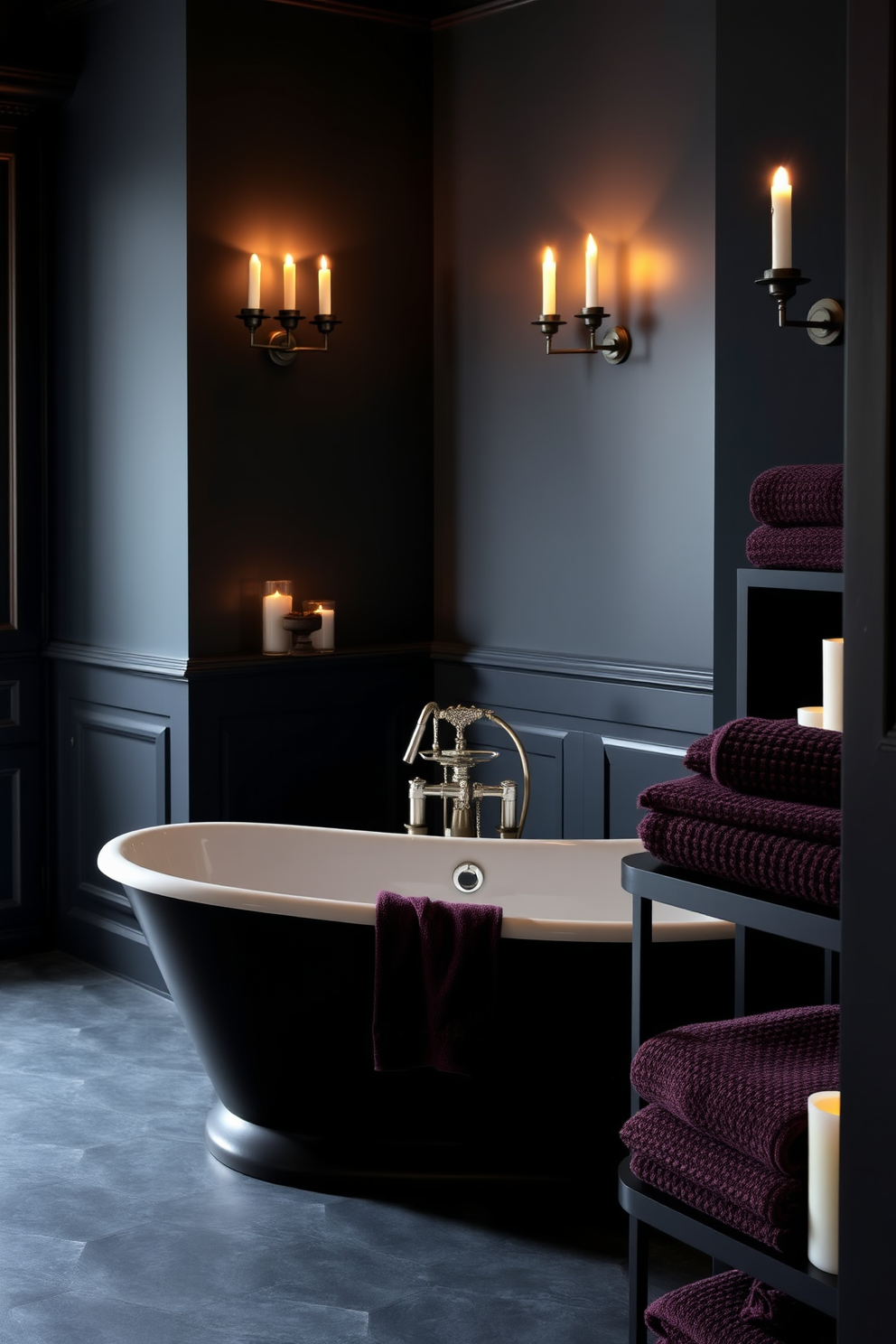 Candlelight flickers softly from elegant sconces mounted on the walls, casting a warm glow throughout the space. The dark color palette features deep charcoal walls and rich black cabinetry, creating a dramatic yet inviting atmosphere. A freestanding bathtub sits at the center, surrounded by candles that enhance the serene vibe. Textured towels in deep plum hues are neatly arranged on a nearby shelf, adding a touch of luxury to the overall design.